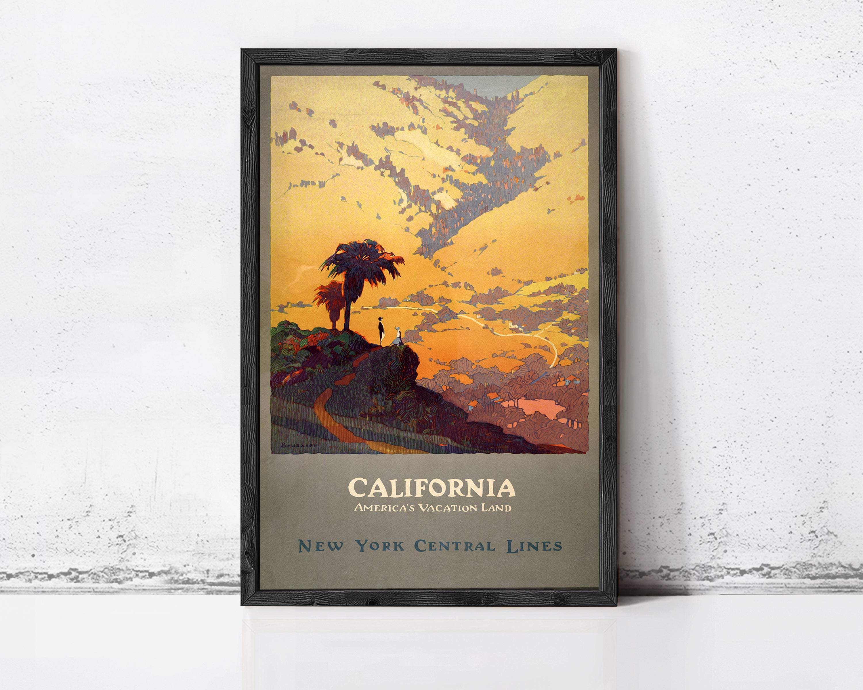 A framed vintage poster depicting a scenic landscape with a palm tree, mountains, and a sunset sky, advertising California as a vacation land.