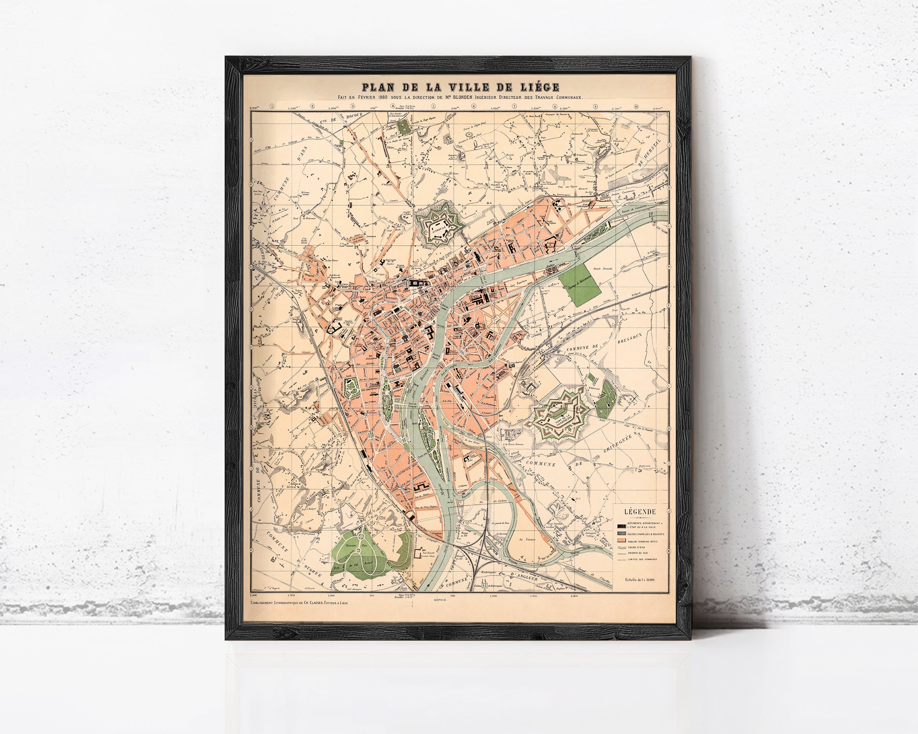 The image is a framed vintage map of a city, depicting various landmarks and streets.