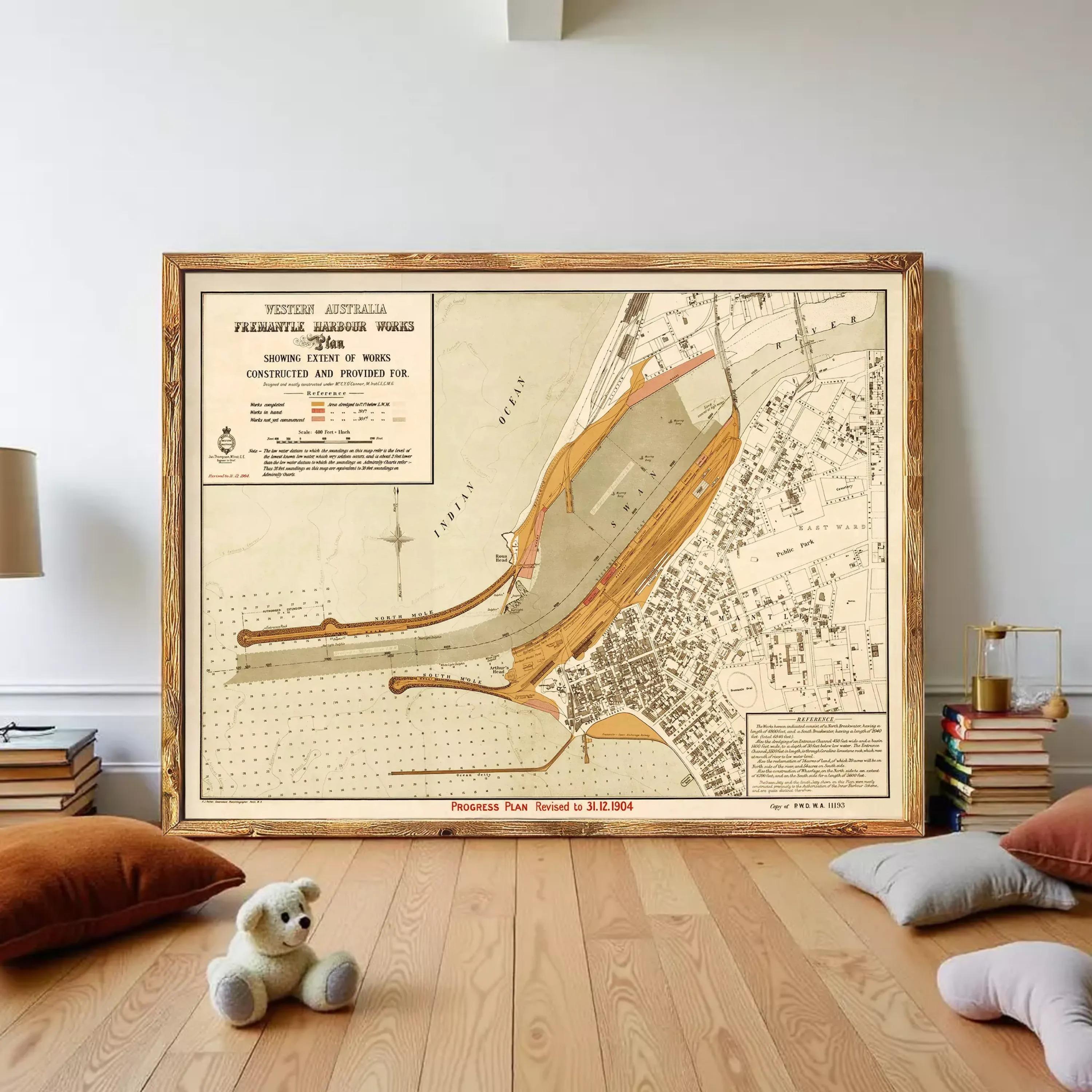 a large framed map of Western Australia, with a teddy bear sitting on the floor in front of it.