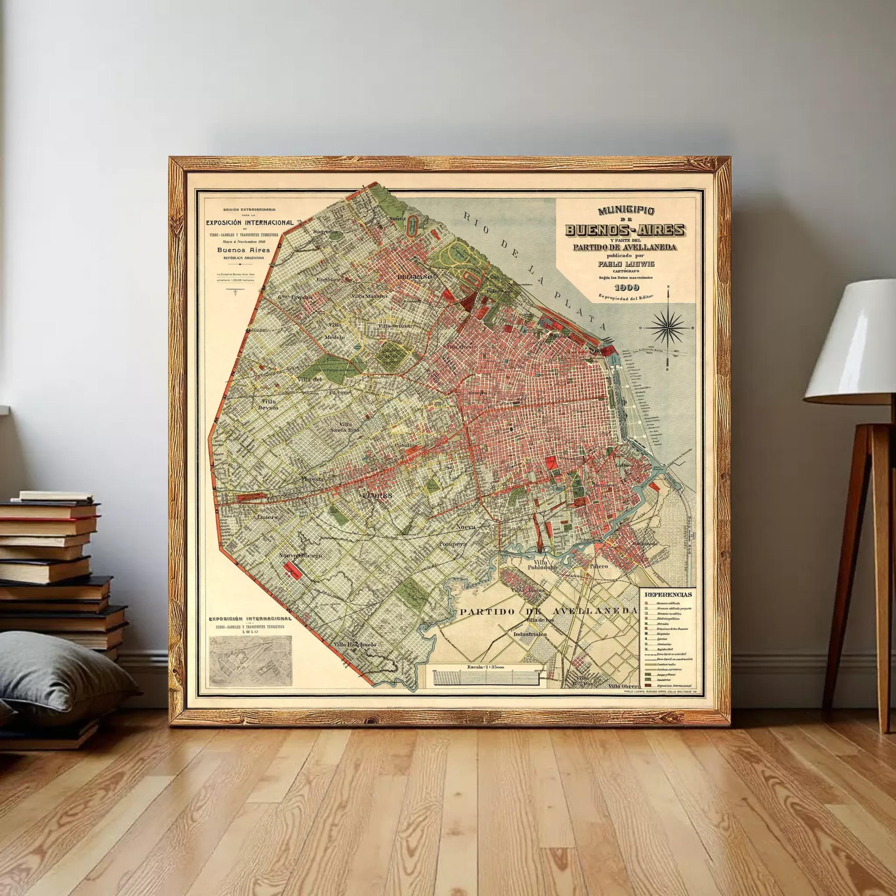 The image is a framed vintage map of a city, likely from the early 20th century, depicting a detailed layout of the city's streets, landmarks, and surrounding areas.