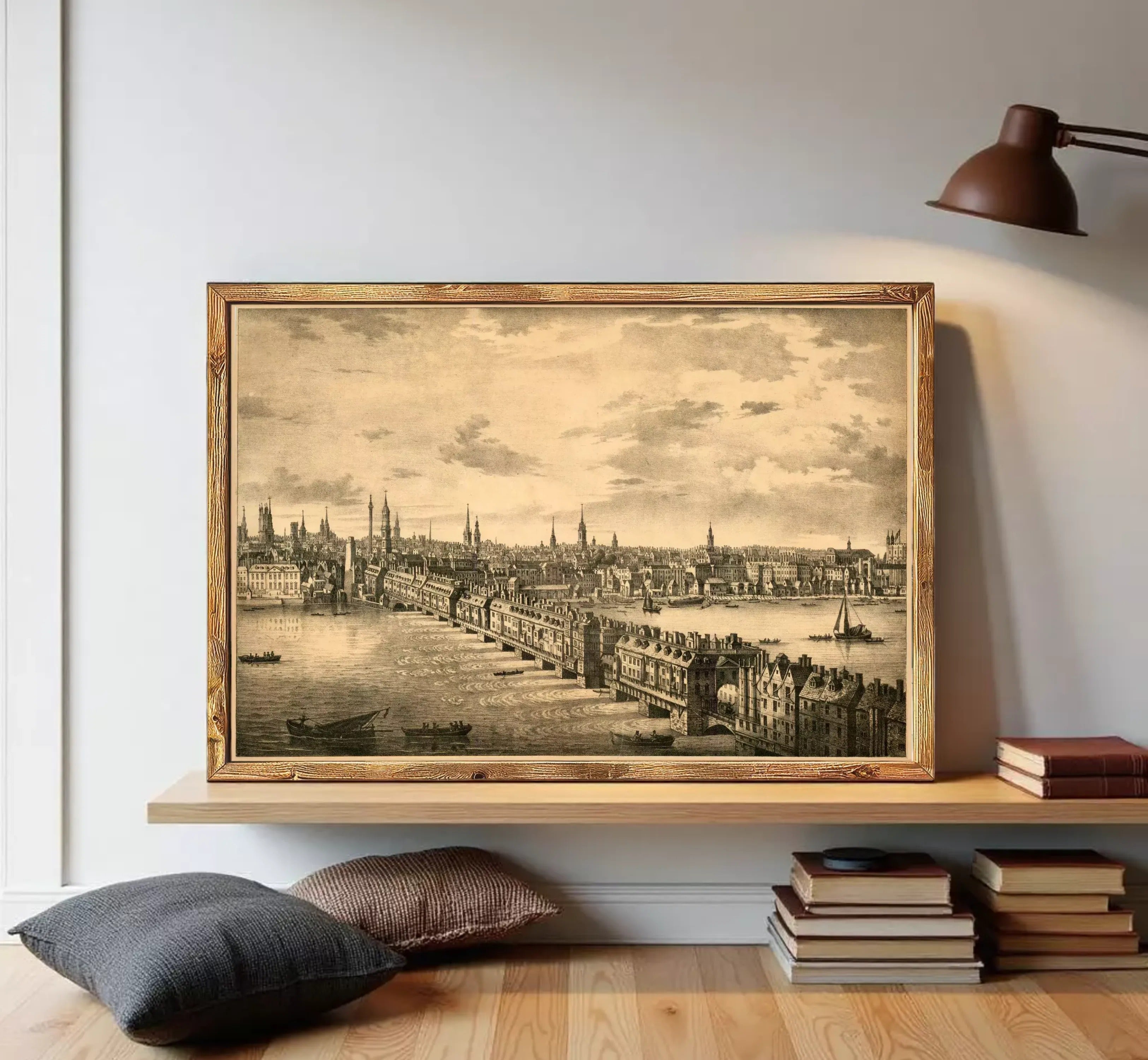 A framed black and white illustration depicting a cityscape with a river and boats, set against a cloudy sky.
