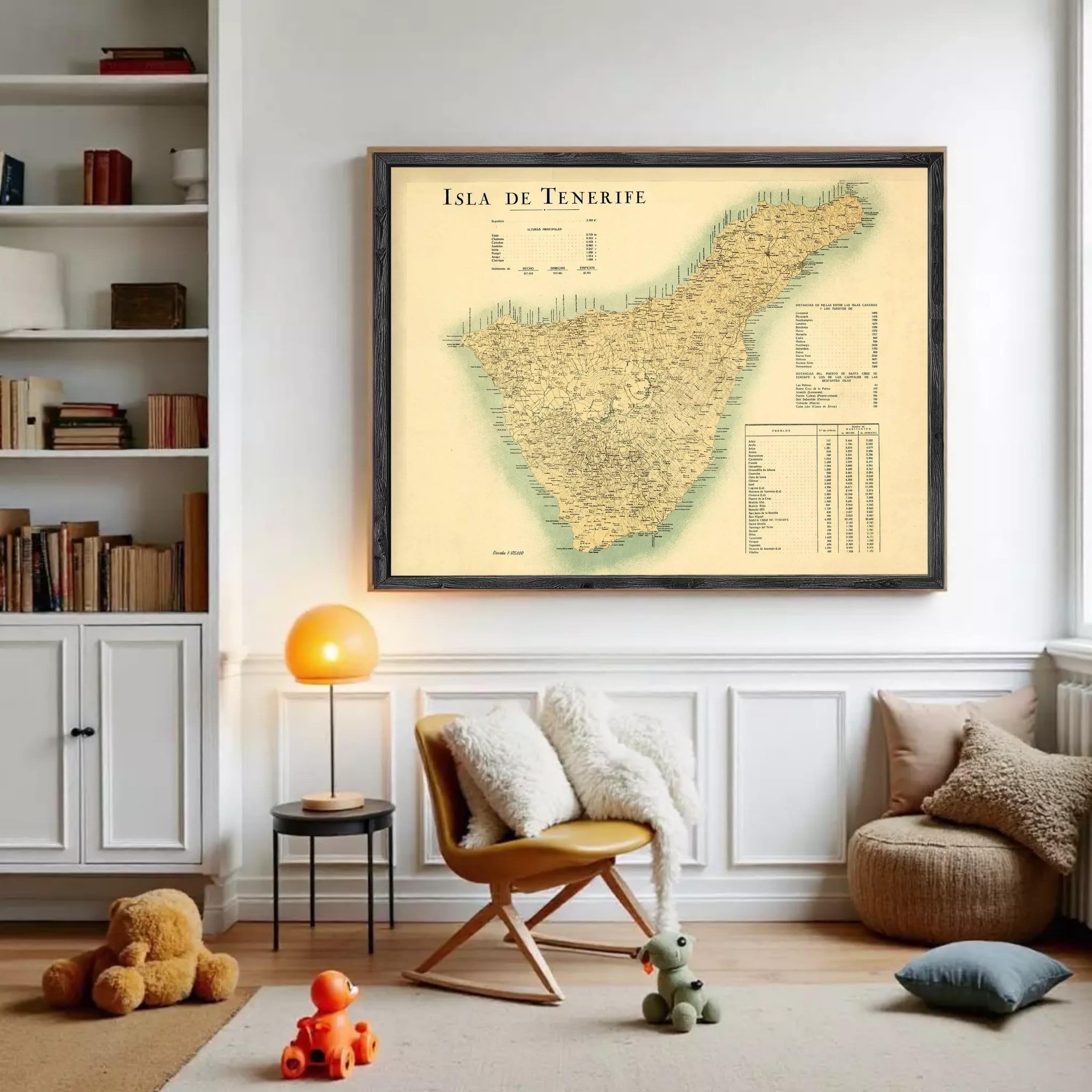 a cozy living room with a large framed map of the island of Tenerife hanging on the wall. The room is decorated with various items, including a bookshelf filled with books, a chair, a small table with a lamp, and a teddy bear. There is also a teddy bear and a toy car in the room, adding a playful touch to the space.