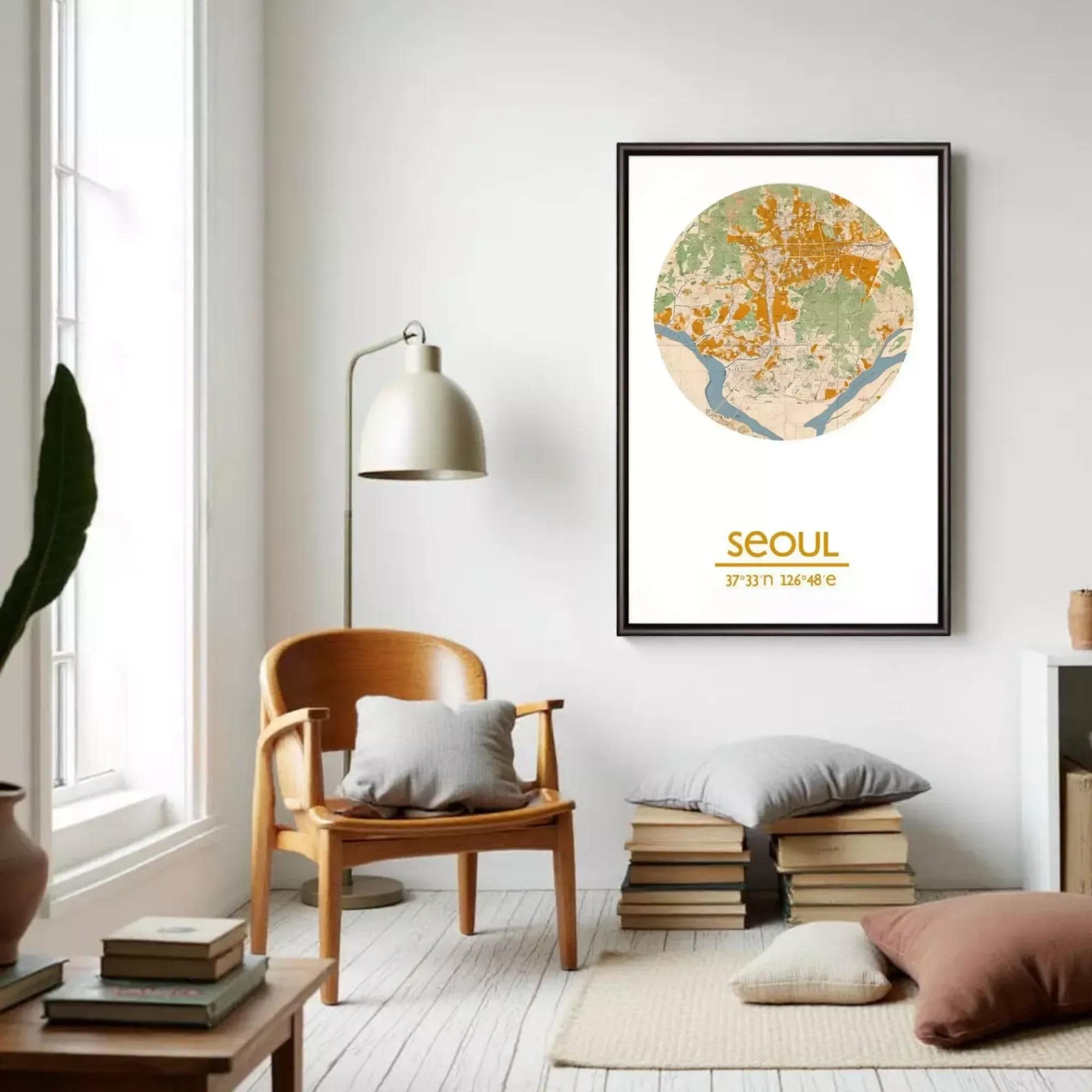 a living room with a wooden chair, a lamp, and a stack of books. A framed map of Seoul, South Korea, is hanging on the wall above the chair.