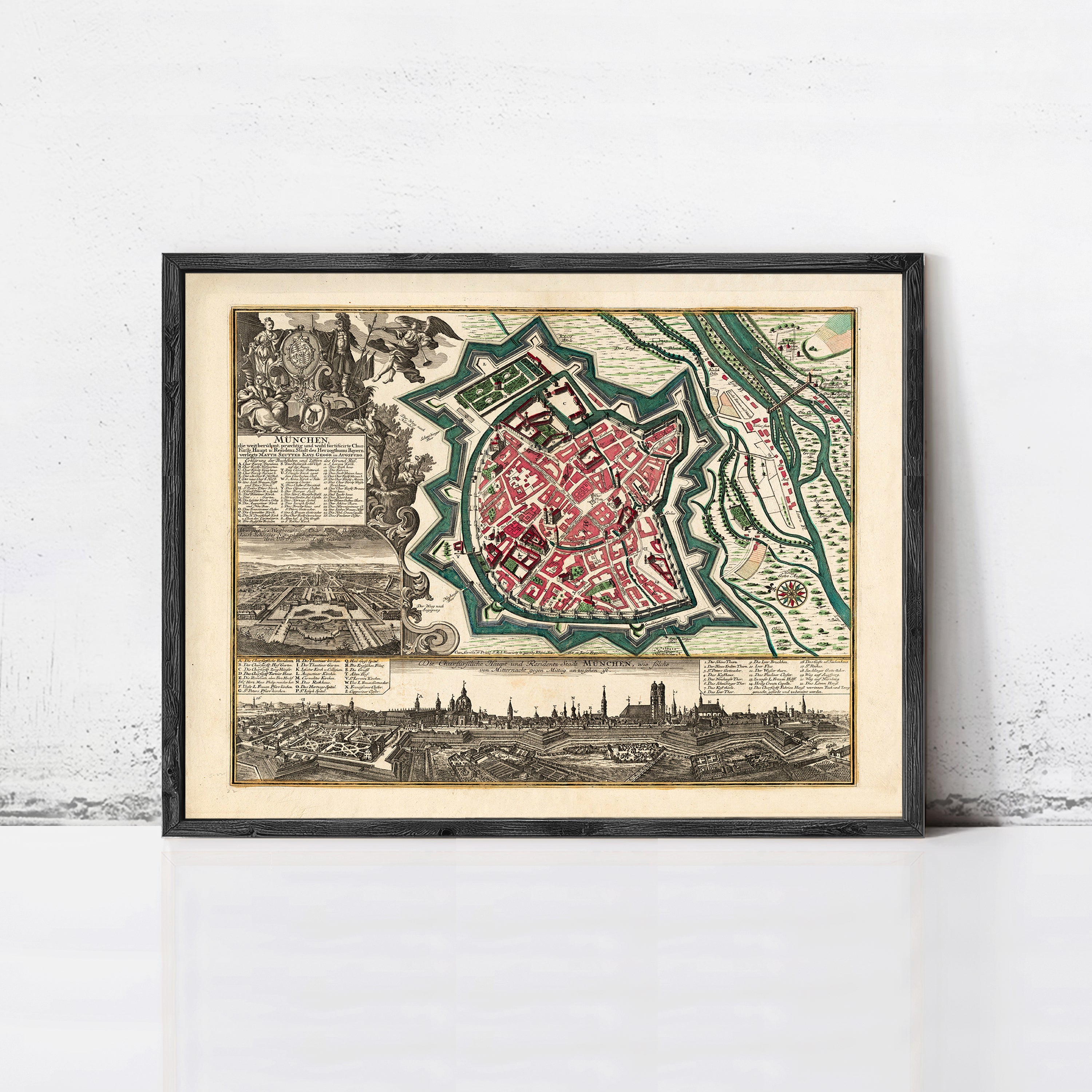 The image is a framed vintage map of a city, depicting a detailed layout of the city's streets, buildings, and surrounding landscape.