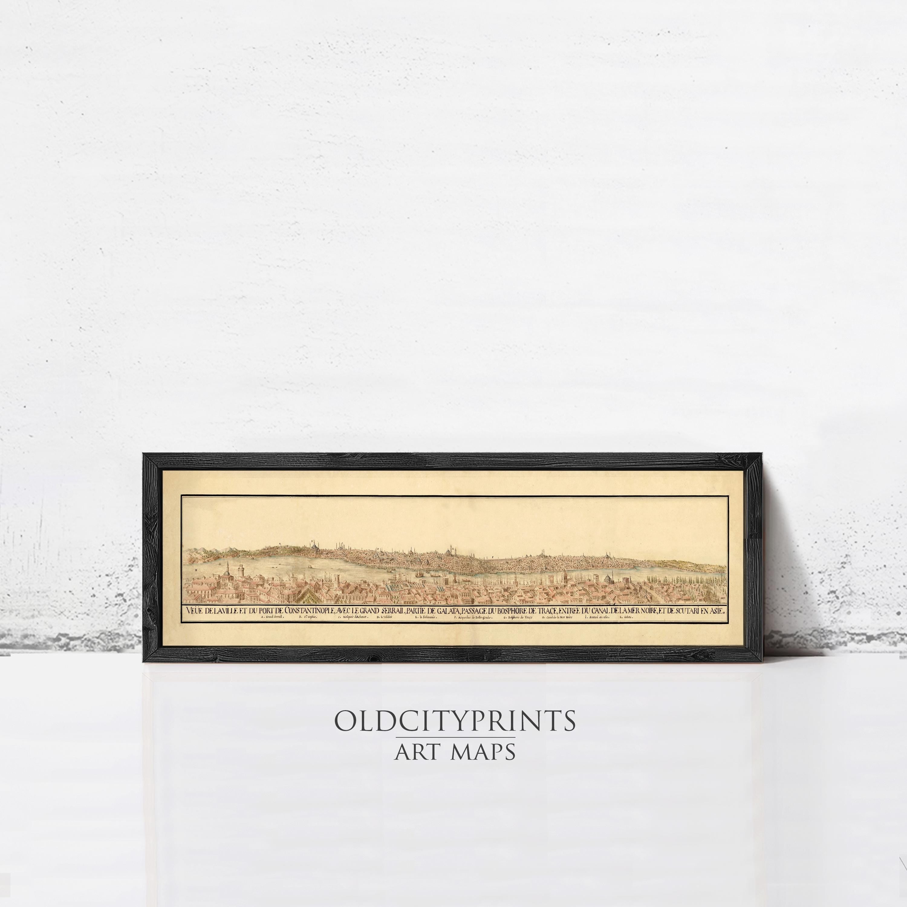 The image is a framed art print depicting a historical map of a city, with a white wall in the background.