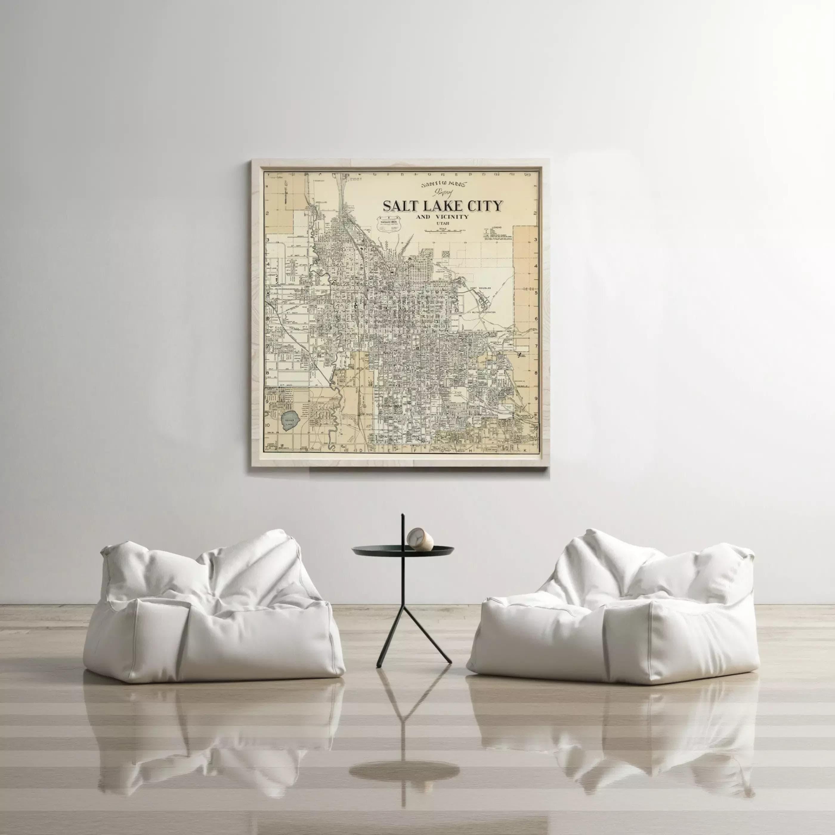 a large framed map of Salt Lake City hanging on a white wall, with two white bean bag chairs positioned in front of it.