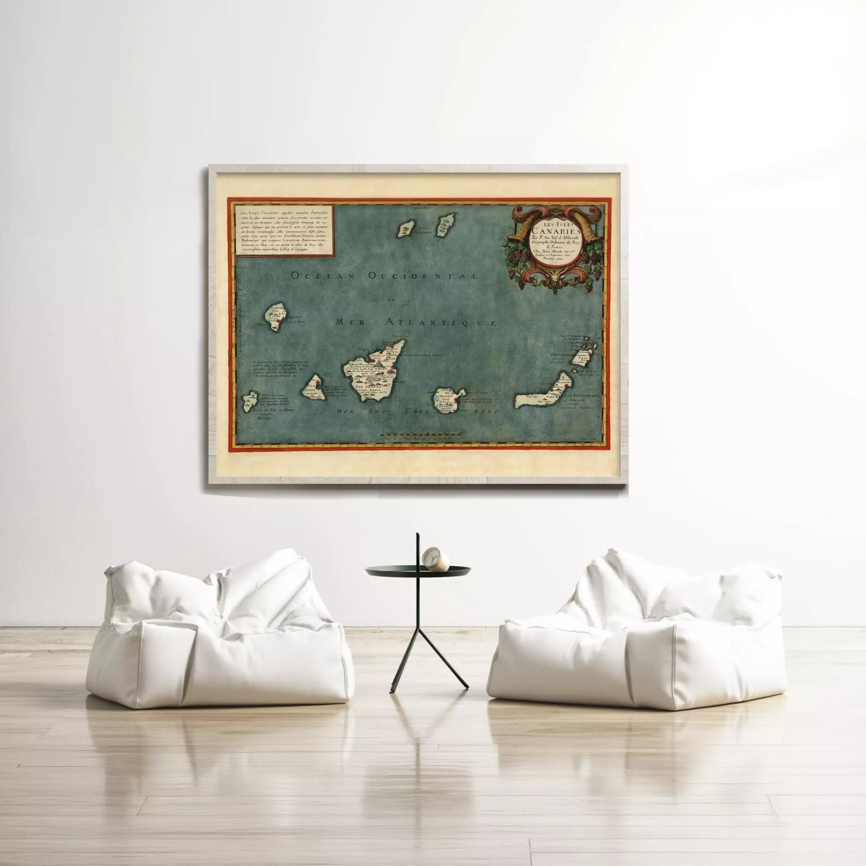 a large framed map of the Caribbean Sea hanging on a white wall, with two white bean bag chairs positioned in front of it.