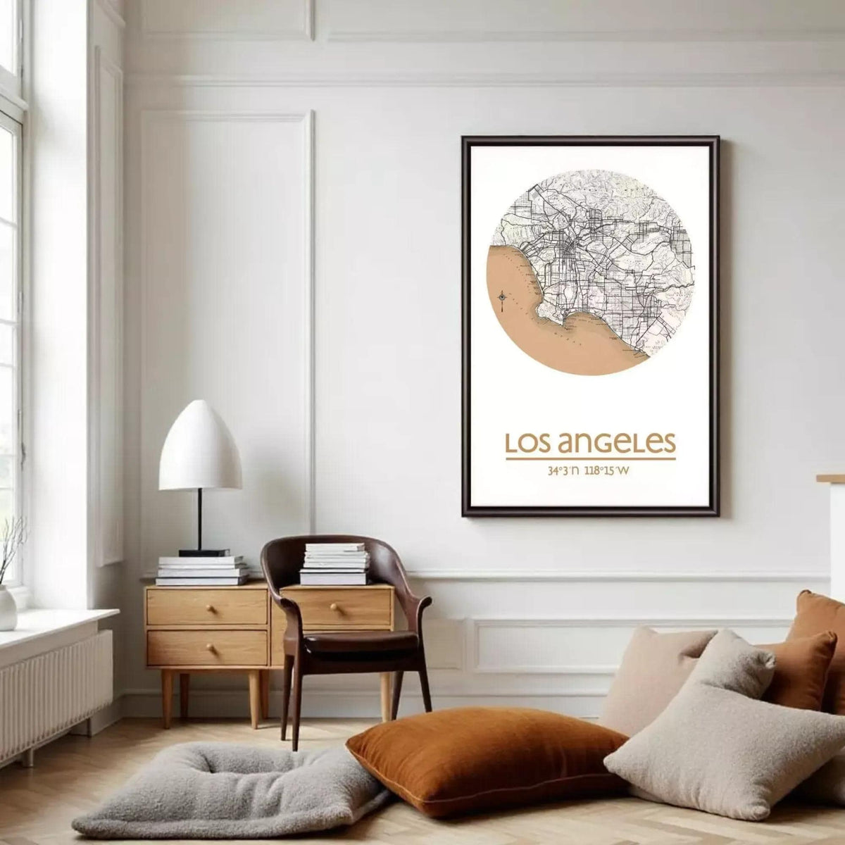 a living room with a framed map of Los Angeles hanging on the wall. The room has a minimalist and modern design, with a wooden chair, a lamp, and a stack of books on a table.