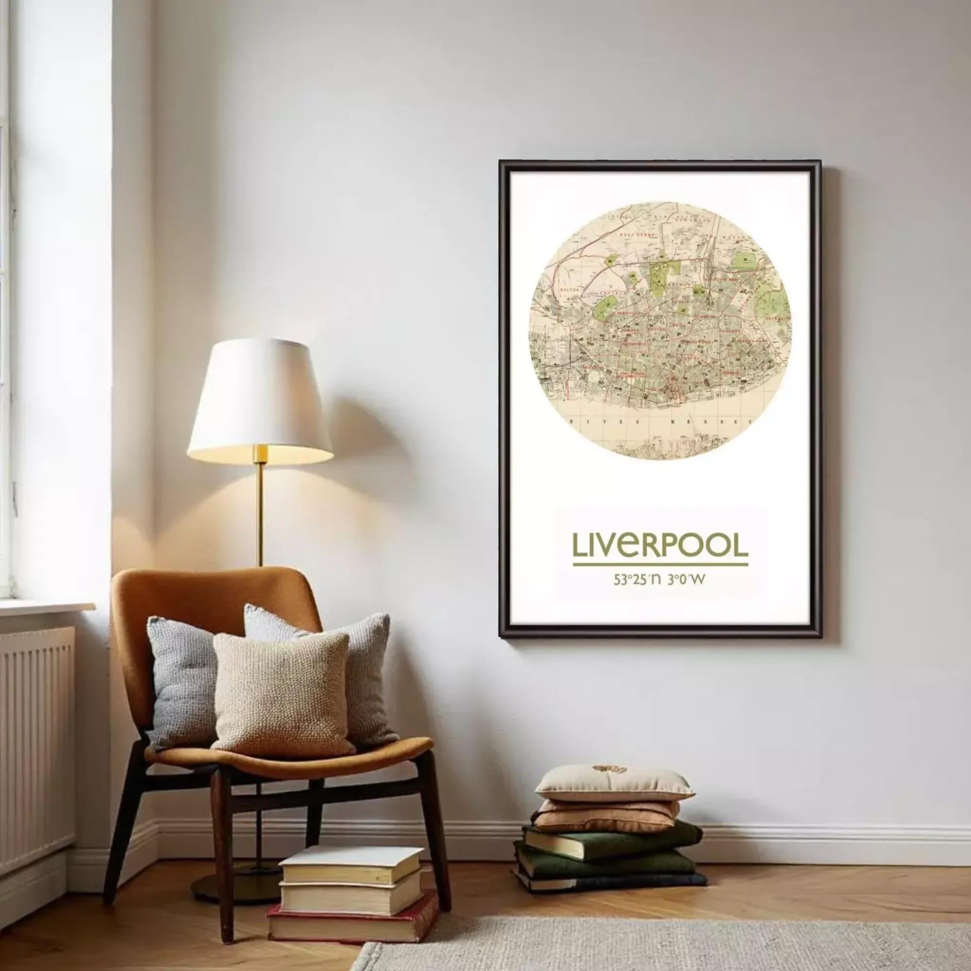 a framed map of Liverpool, with a lamp and a stack of books on the floor in front of it.