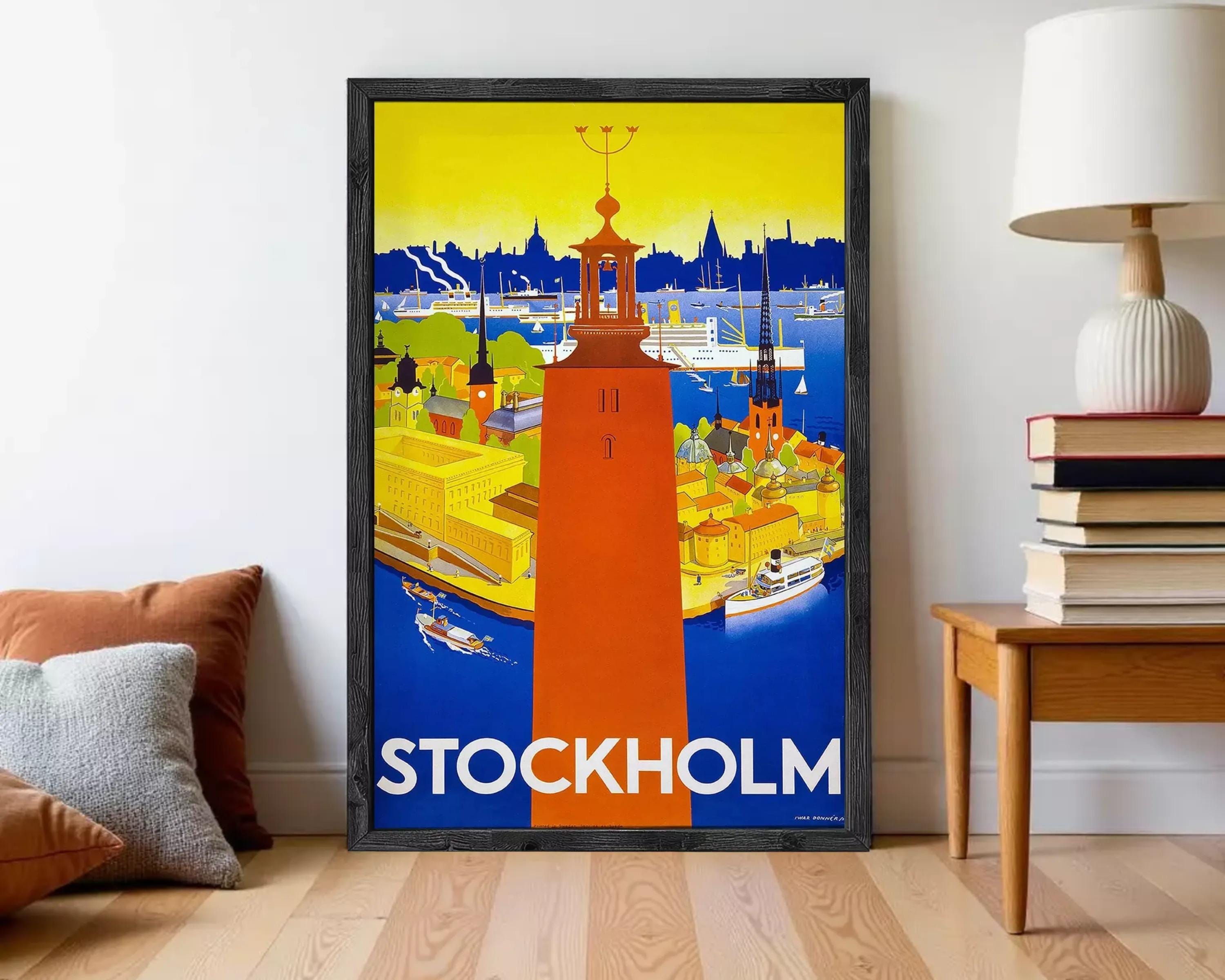 A framed poster of a cityscape with a tall tower in the center, surrounded by various buildings and boats. The text "STOCKHOLM" is prominently displayed at the bottom of the poster.