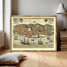The image is a framed vintage map of a coastal city, depicting a bustling harbor filled with ships and boats.