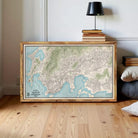 a large framed map of a city or region, with a wooden floor and a lamp in the background.