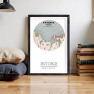 A framed map of Astoria, Oregon, with the text "astoria" and "46°11'11" 49°15' W" printed on it, is displayed on a wooden floor next to a stack of books.