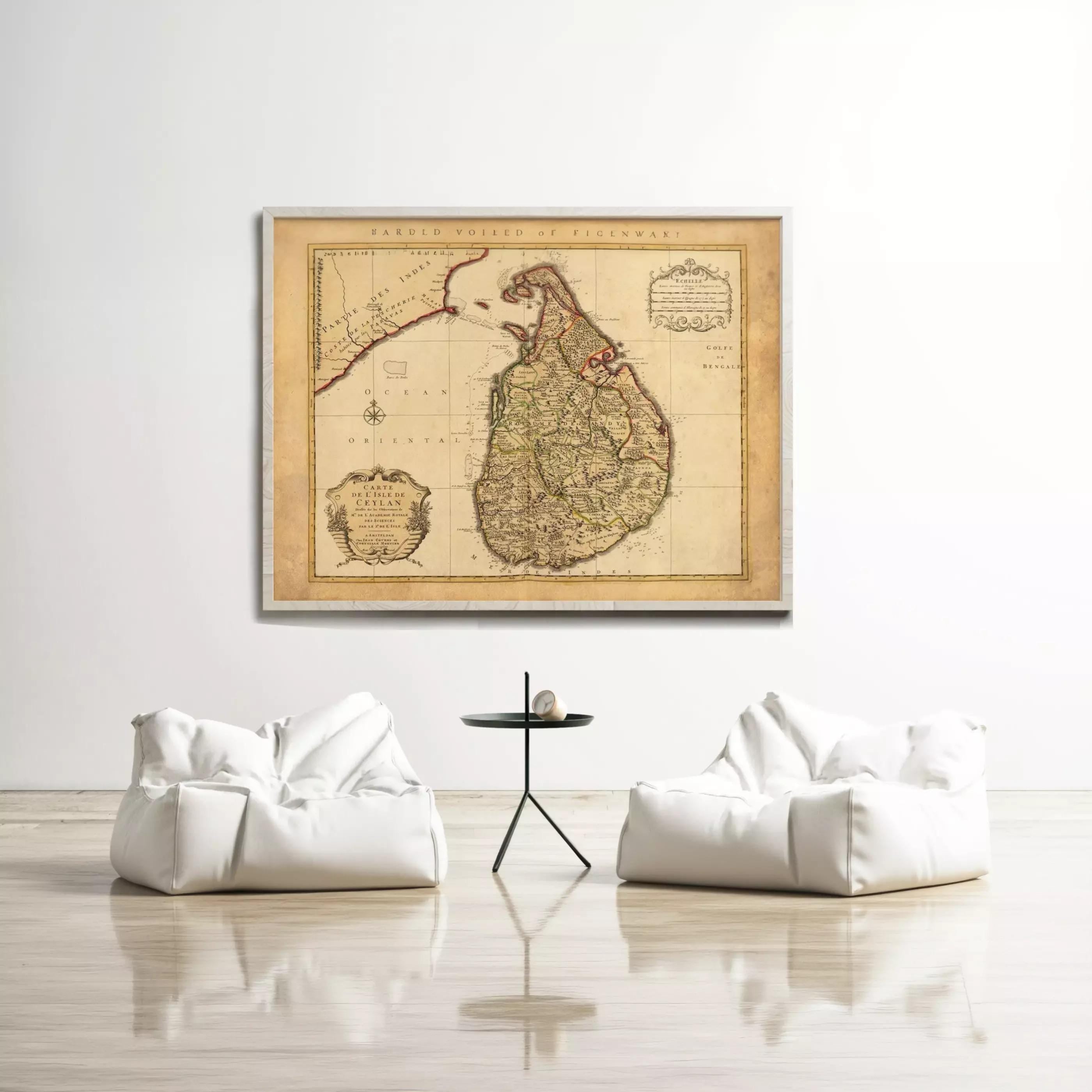 a large antique map of Sri Lanka hanging on a white wall, with two white bean bag chairs positioned in front of it.