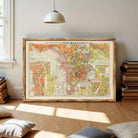 The image is a framed vintage map of a city, likely from the early 20th century, with a color palette of orange, green, and brown.