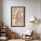 The image is a framed vintage map of New York City, depicting the city's streets and neighborhoods in a detailed and colorful manner.