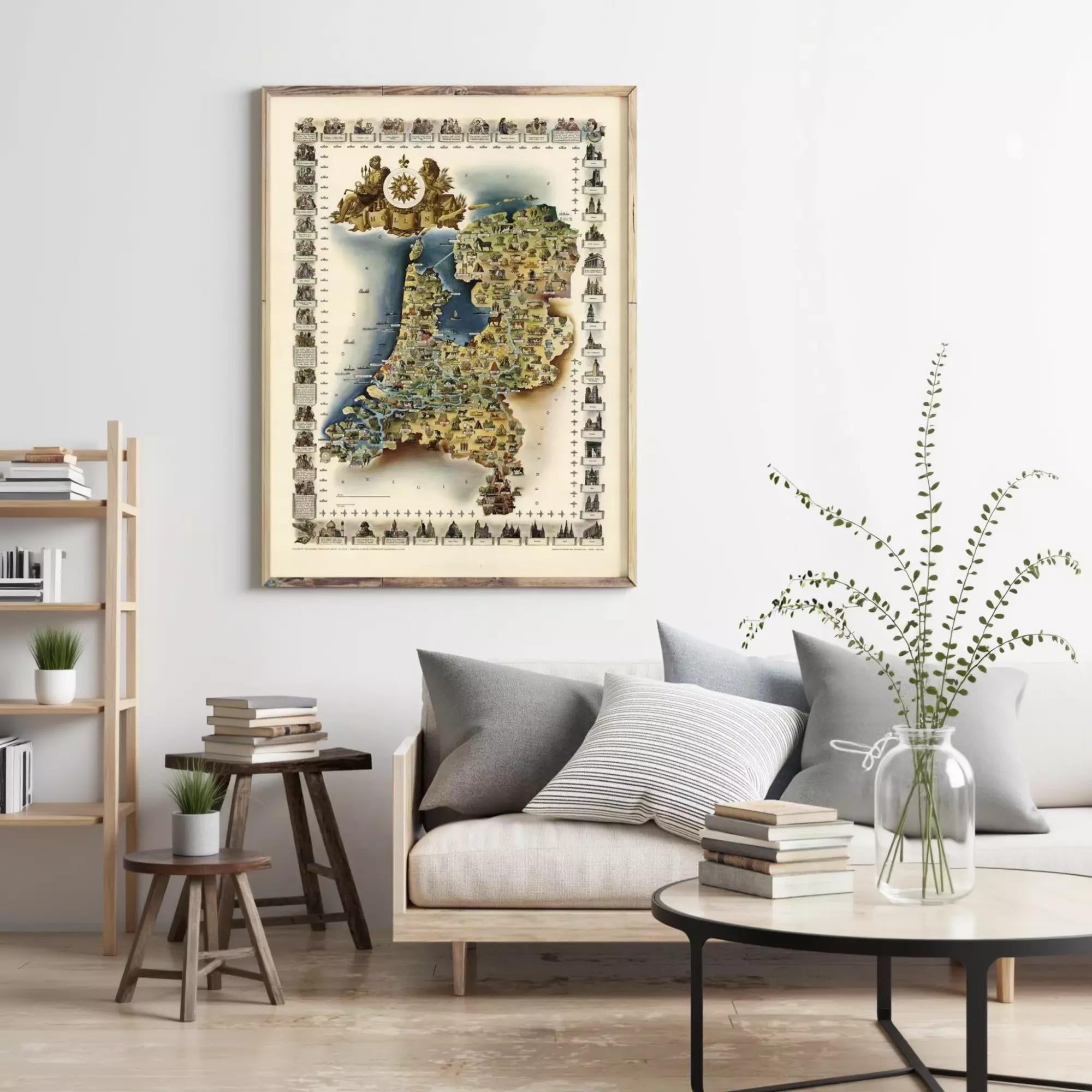 a living room with a large framed map of the Netherlands hanging on the wall above a couch with pillows. There are also some books and decorative items on the couch and coffee table.