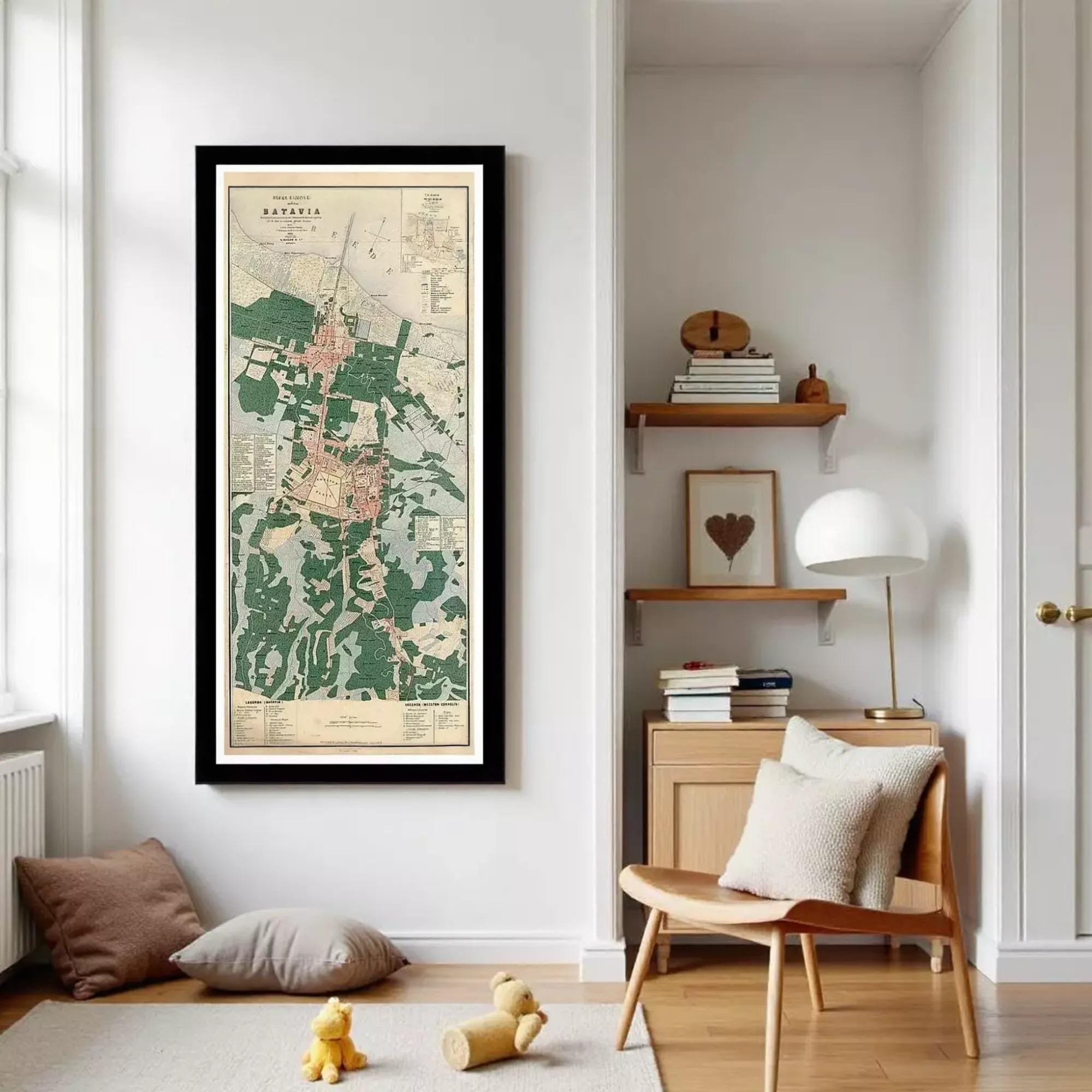 a living room with a large framed map of Banyai hanging on the wall, a wooden side table with a lamp, and a chair. There are also some books and a teddy bear on the floor.