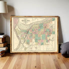 The image is a framed vintage map of the city of Kansas City, Missouri, with a detailed layout of streets, neighborhoods, and bodies of water.