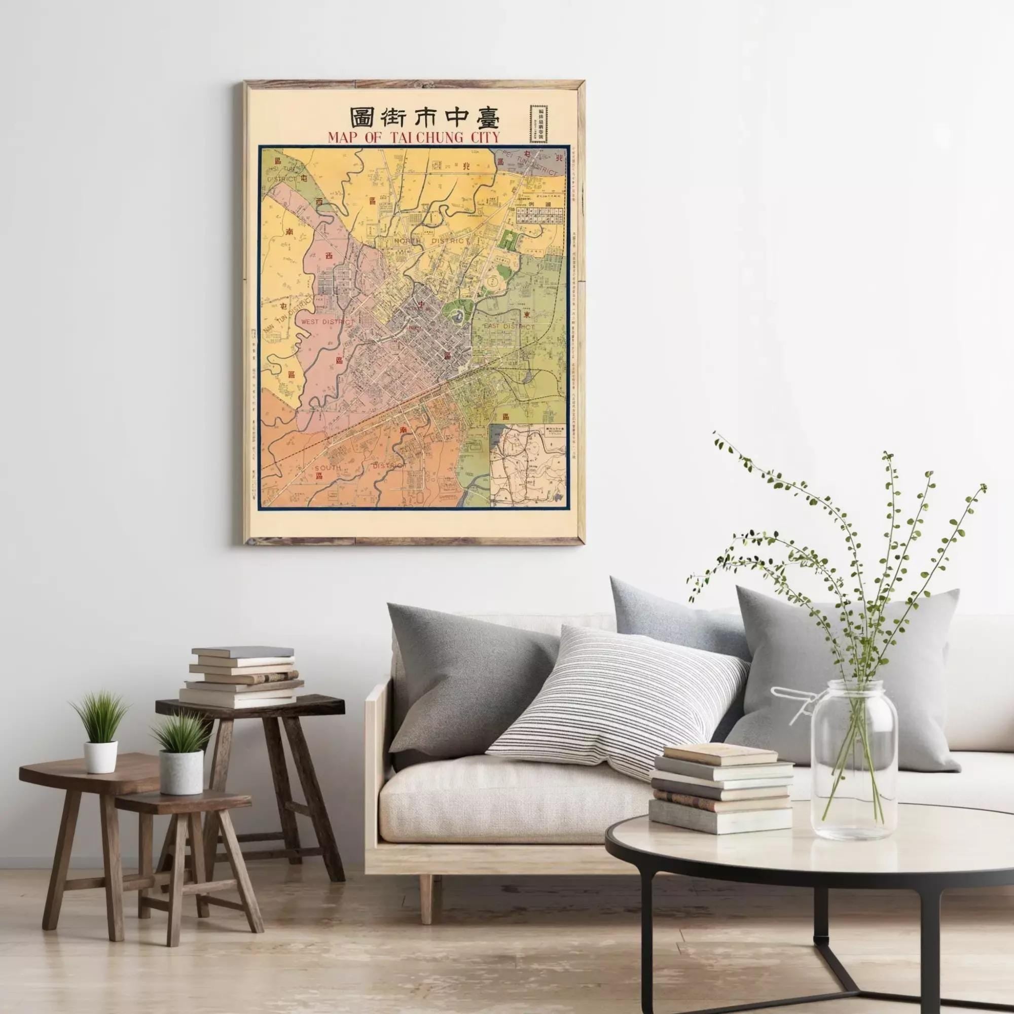a living room with a large framed map of Taipei City hanging on the wall. The room has a gray sofa, a wooden coffee table, and a few potted plants.