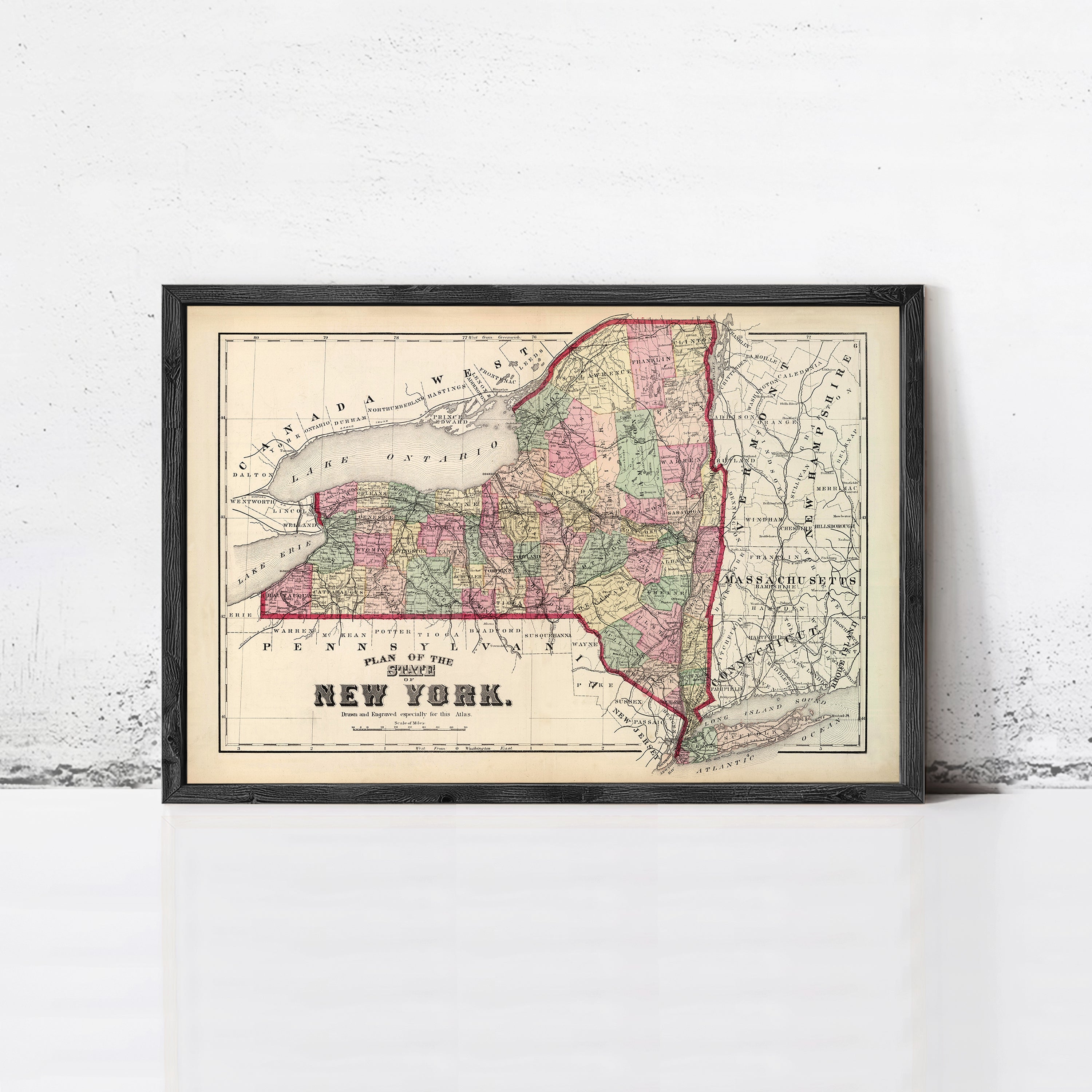 A framed map of New York State, depicting the state's geographical layout and surrounding areas.