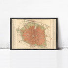 The image is a framed vintage map of a city, depicting a detailed layout of streets, buildings, and other urban features.