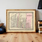 A framed map of Detroit, Michigan, with a vintage style and a pink background.