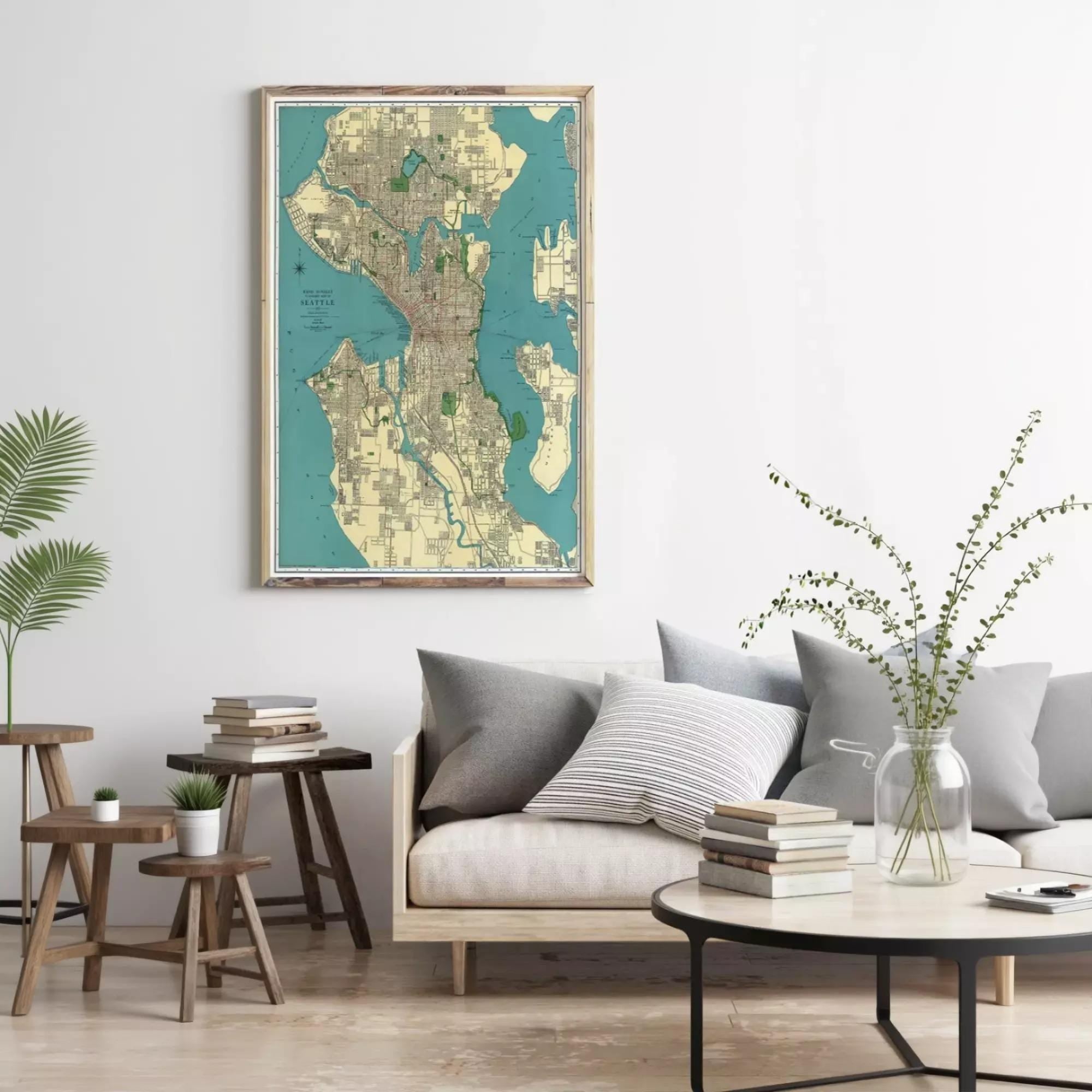 a living room with a large framed map of Seattle, Washington, displayed on the wall above a gray sofa. The room has a wooden coffee table, a potted plant, and a stack of books on the floor.