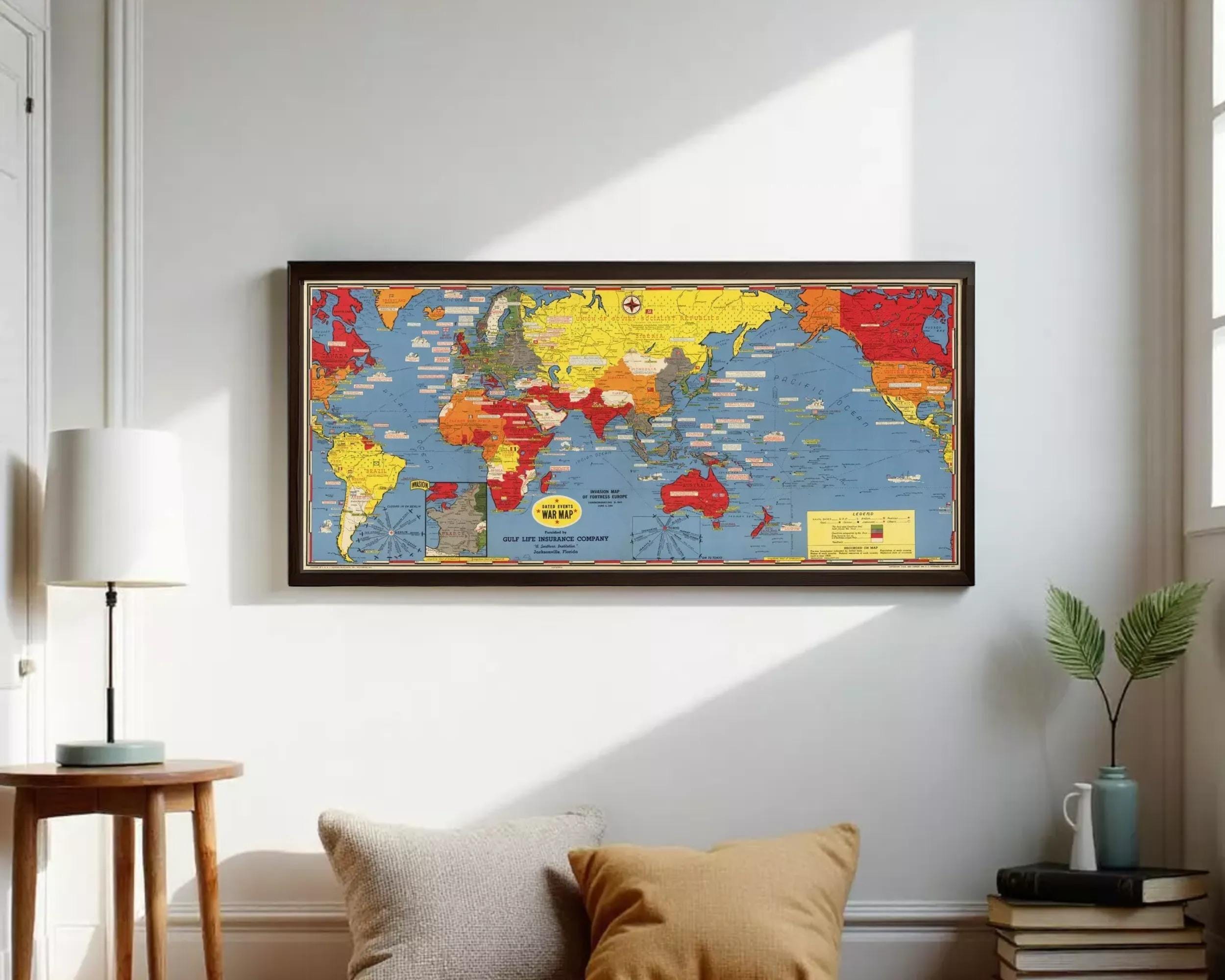 A framed vintage world map with colorful country borders and labels, displayed on a white wall.