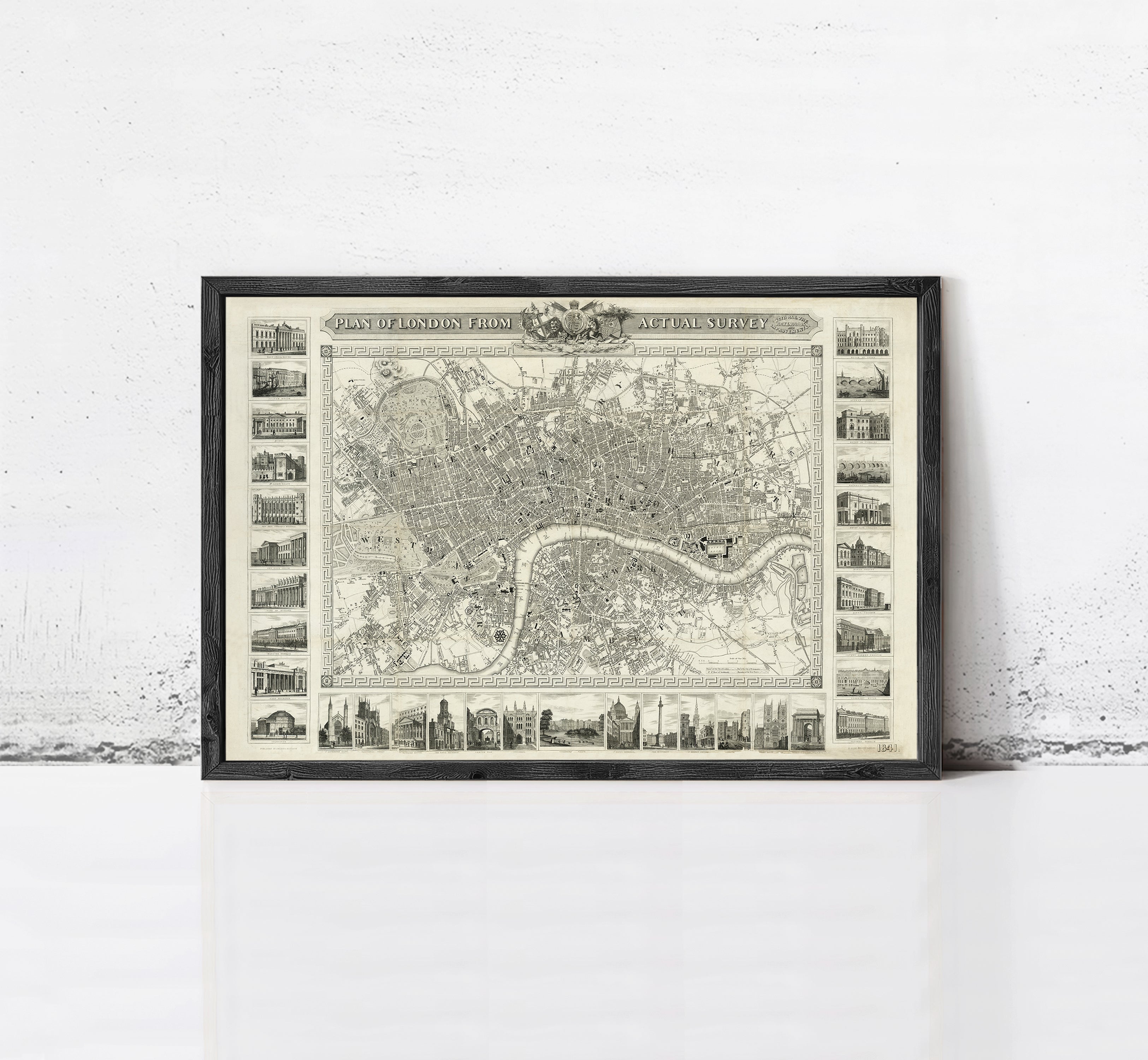 The image is a framed vintage map of London, England, featuring a detailed illustration of the city's streets, landmarks, and surrounding areas.