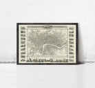 The image is a framed vintage map of London, England, featuring a detailed illustration of the city's streets, landmarks, and surrounding areas.