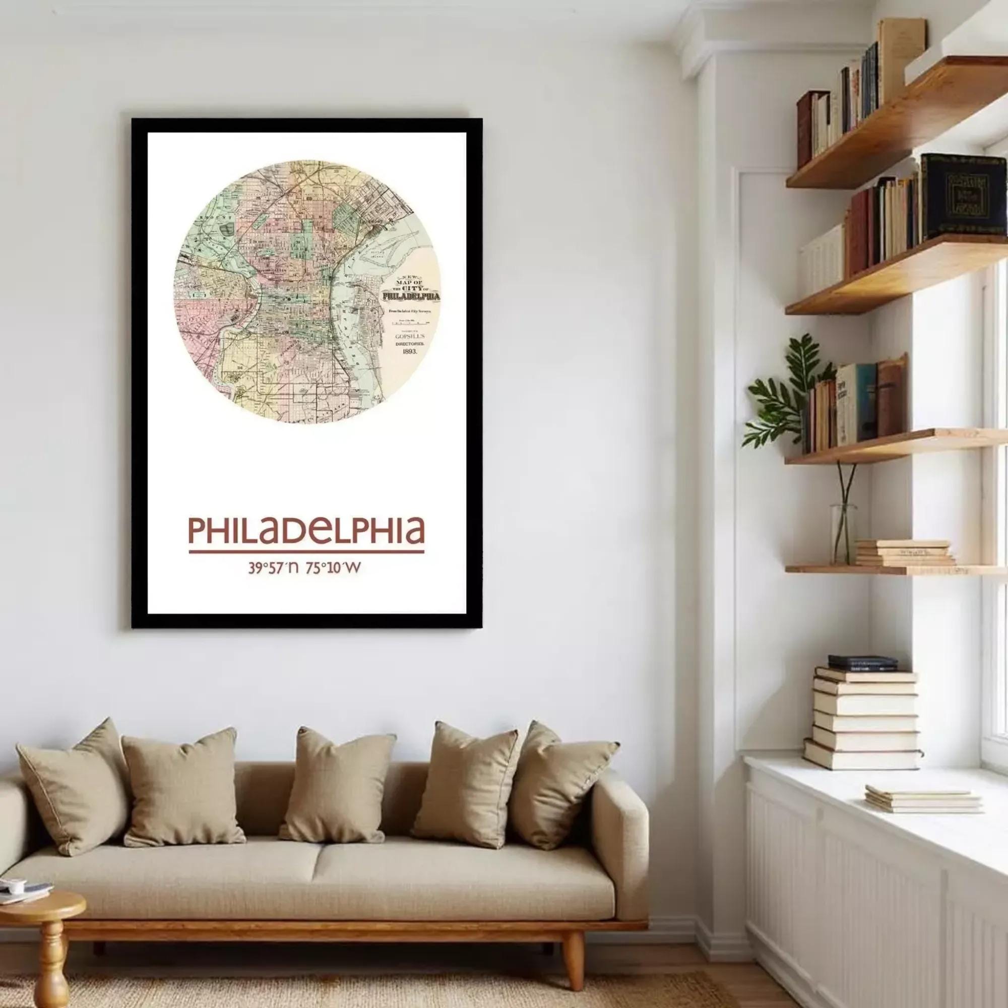 a framed map of Philadelphia hanging on a wall, with a bookshelf and a couch in the foreground.