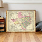 The image is a framed vintage map of Texas, depicting the state in a detailed and colorful manner.