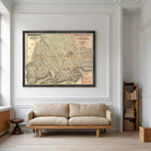 a large framed map of New York City hanging on a white wall in a living room.
