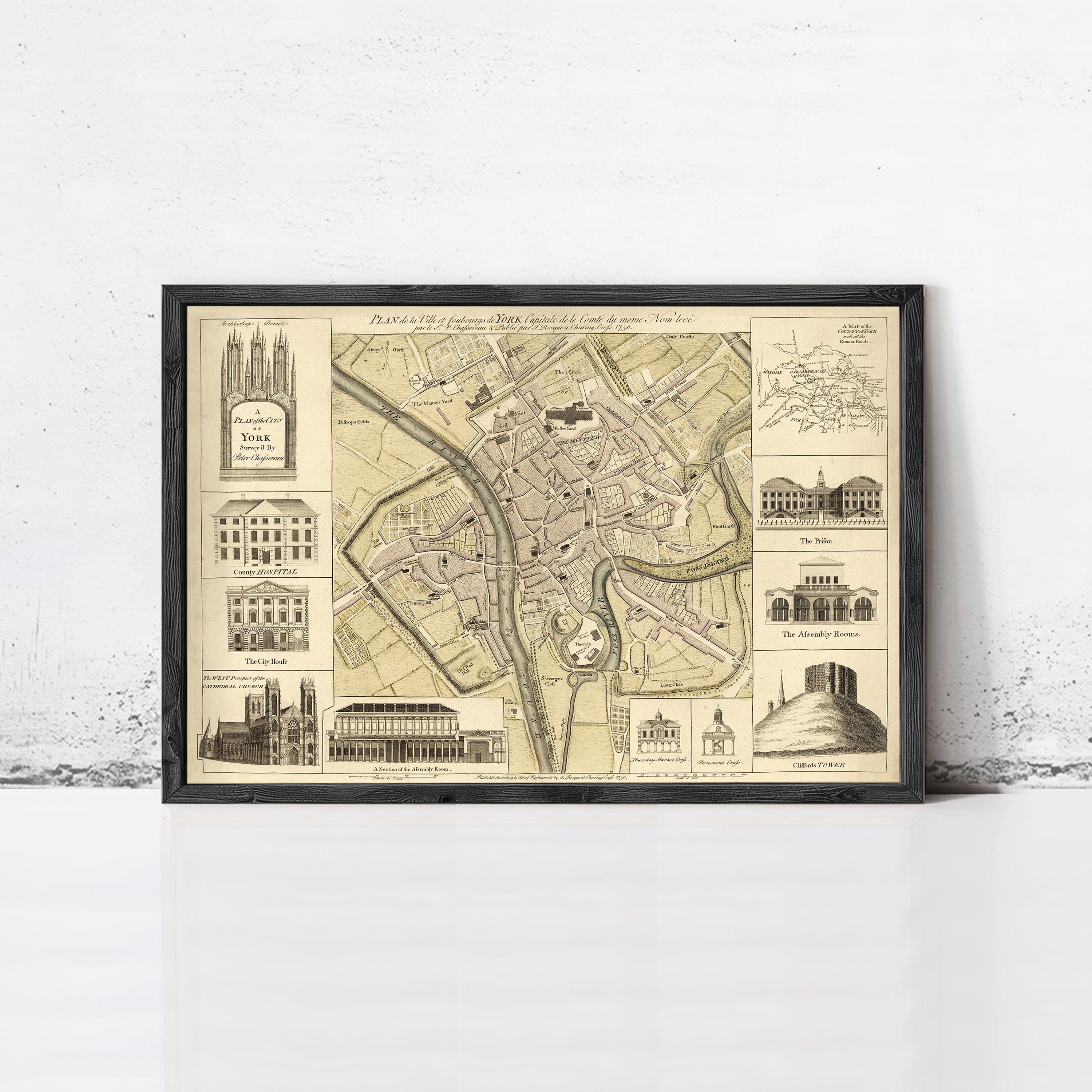 The image is a framed vintage map of a city, featuring various architectural landmarks and buildings.