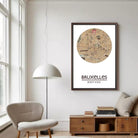 a living room with a large framed map of Bruxelles, Belgium, hanging on the wall. The room has a beige armchair, a wooden side table, and a lamp.