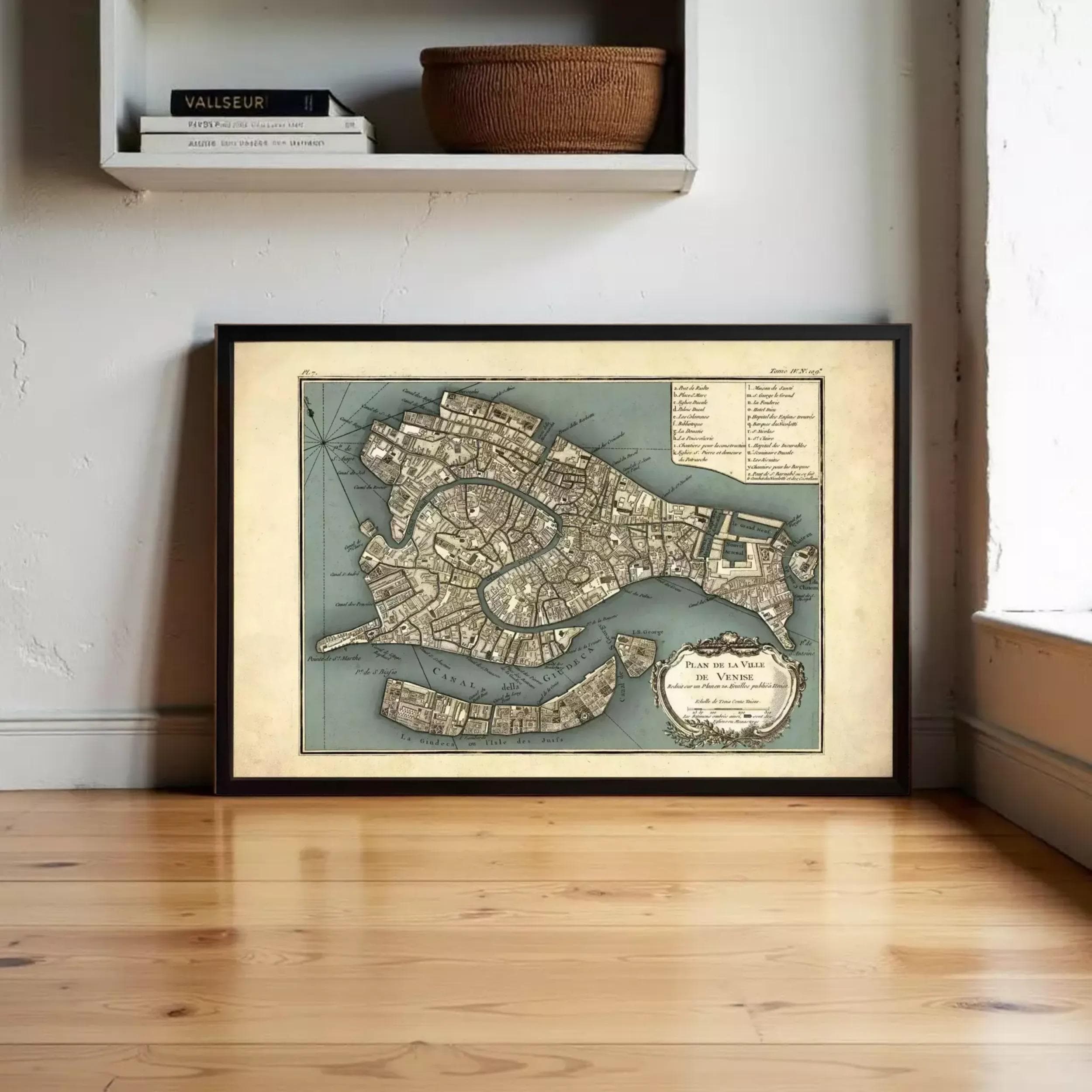 a framed map of Venice, Italy, displayed on a wooden floor in a room.