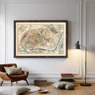 The image is a framed vintage map of a city, depicting various landmarks and streets in a detailed and colorful manner.
