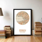 A framed map of Zurich, Switzerland, with a stack of books and a lamp in the background.