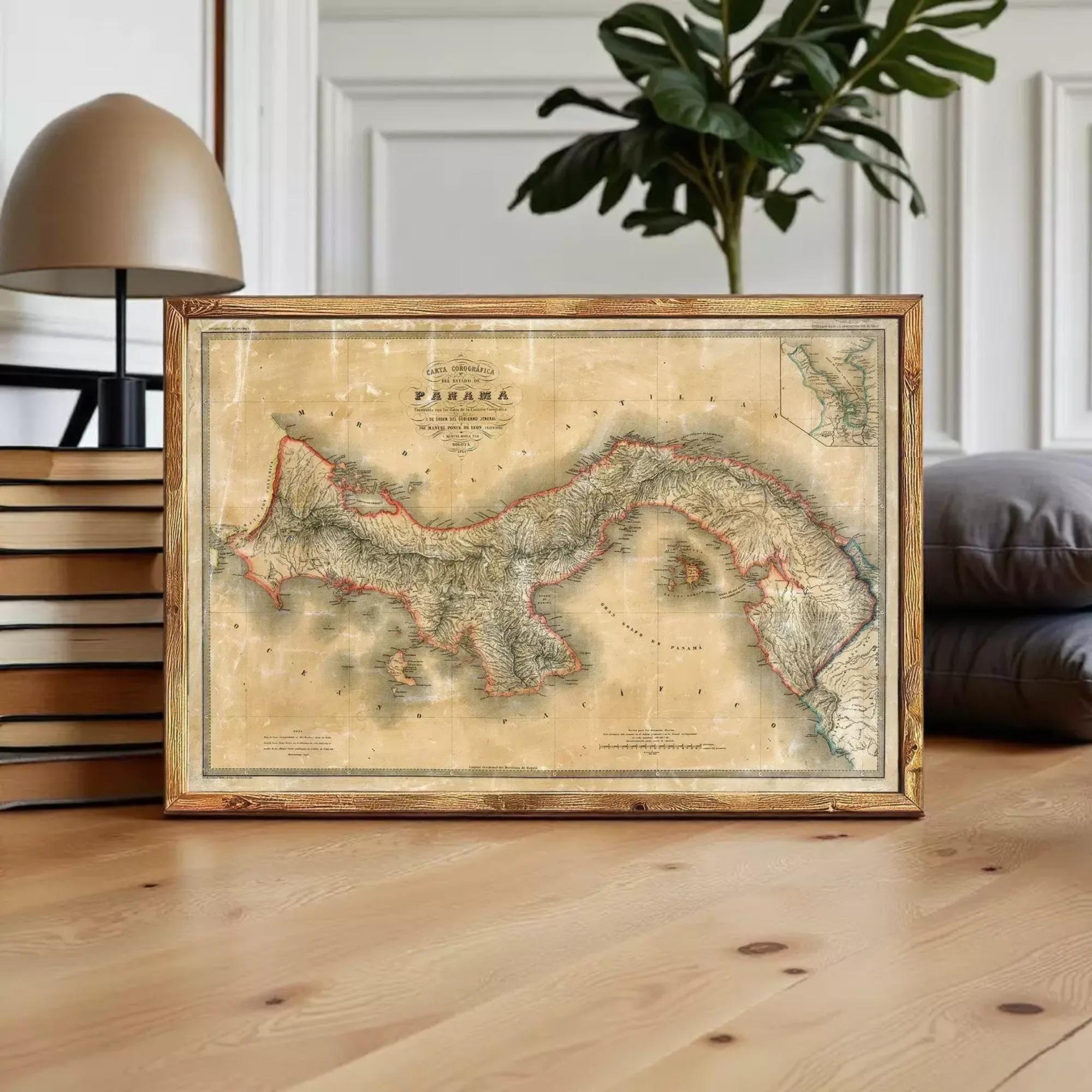 a framed map of Panama, with a lamp and books in the background.