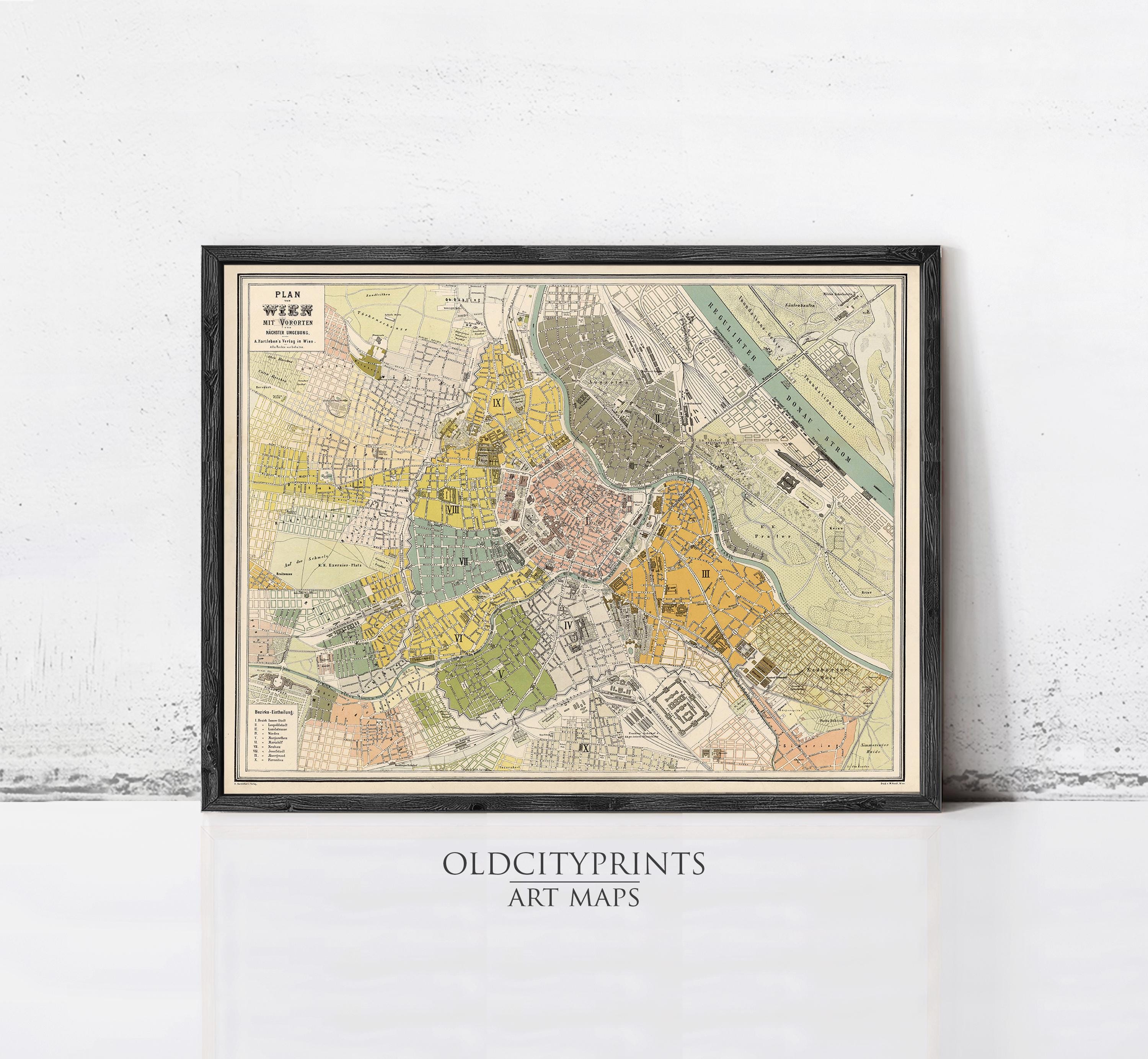 The image is a framed vintage map of a city, likely from the 19th century, displayed on a wall.