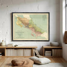a framed map of Costa Rica hanging on a white wall in a room with a wooden floor and a bookshelf.