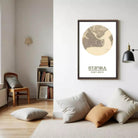 a living room with a framed map of Istanbul hanging on the wall, a bookshelf filled with books, and a wooden chair in the corner.