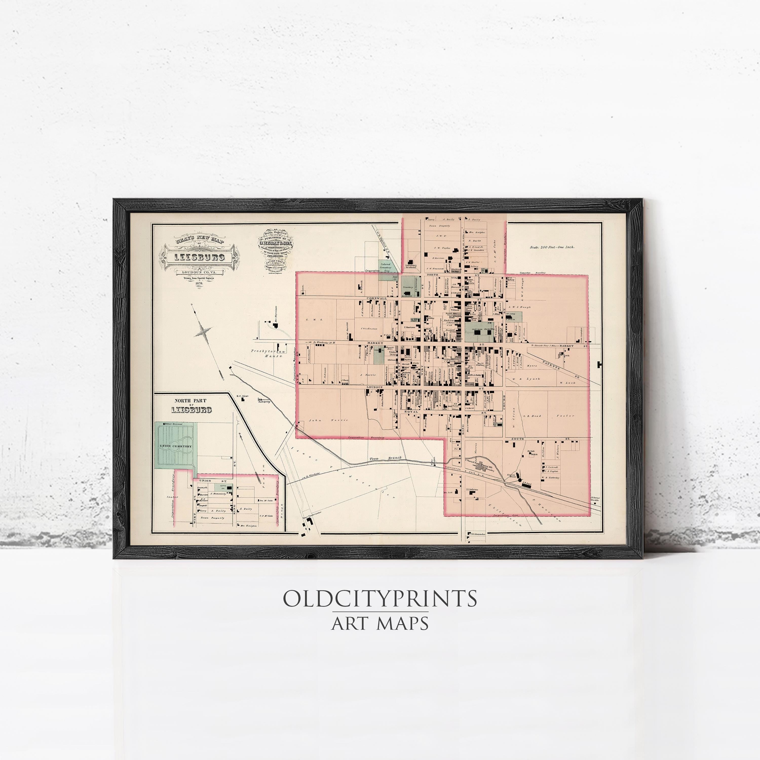 The image is a framed vintage map of a city, likely from the early 20th century, with a black border and a beige background.