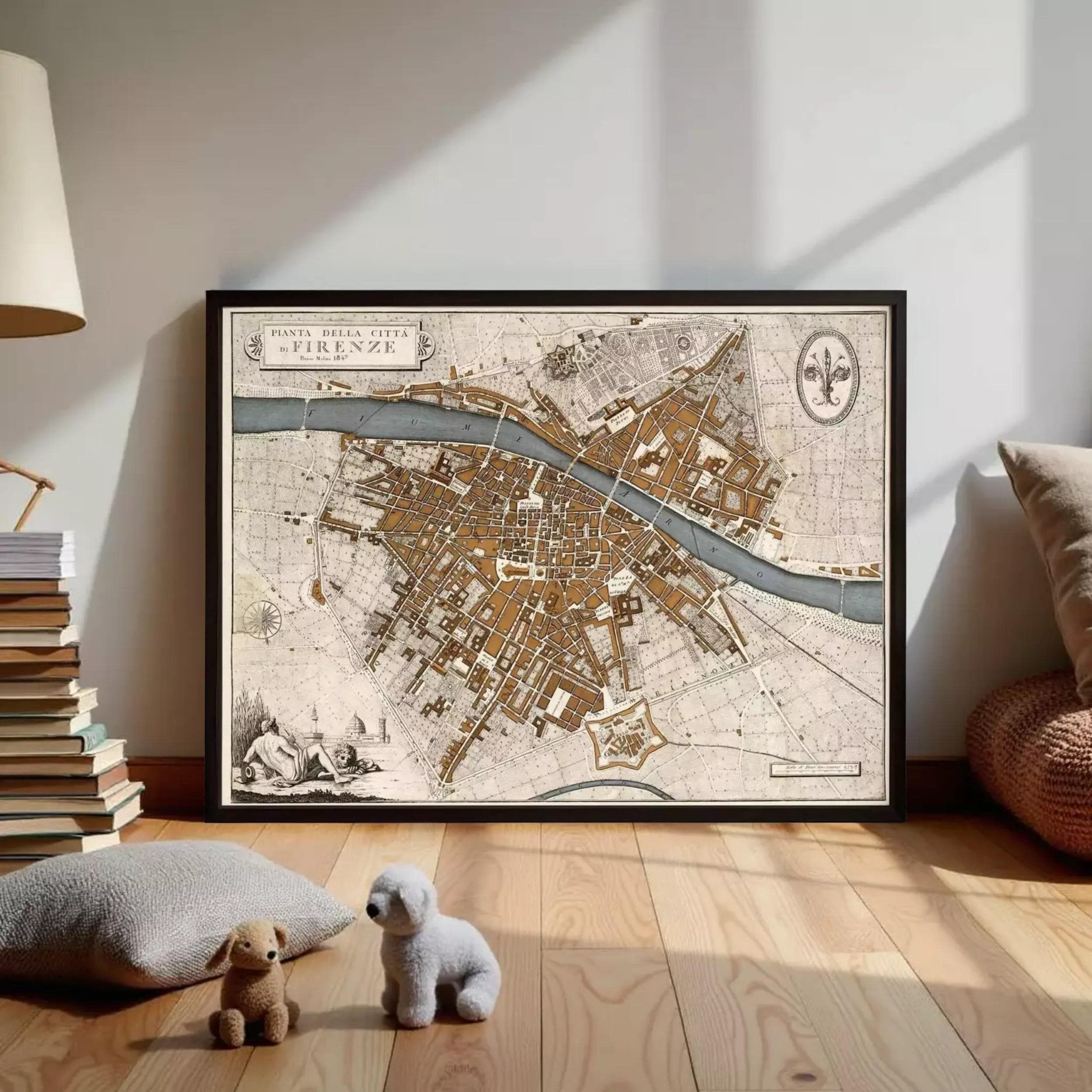 a large framed map of Florence, Italy, with a small stuffed dog and a stuffed bear placed in front of it on a wooden floor.