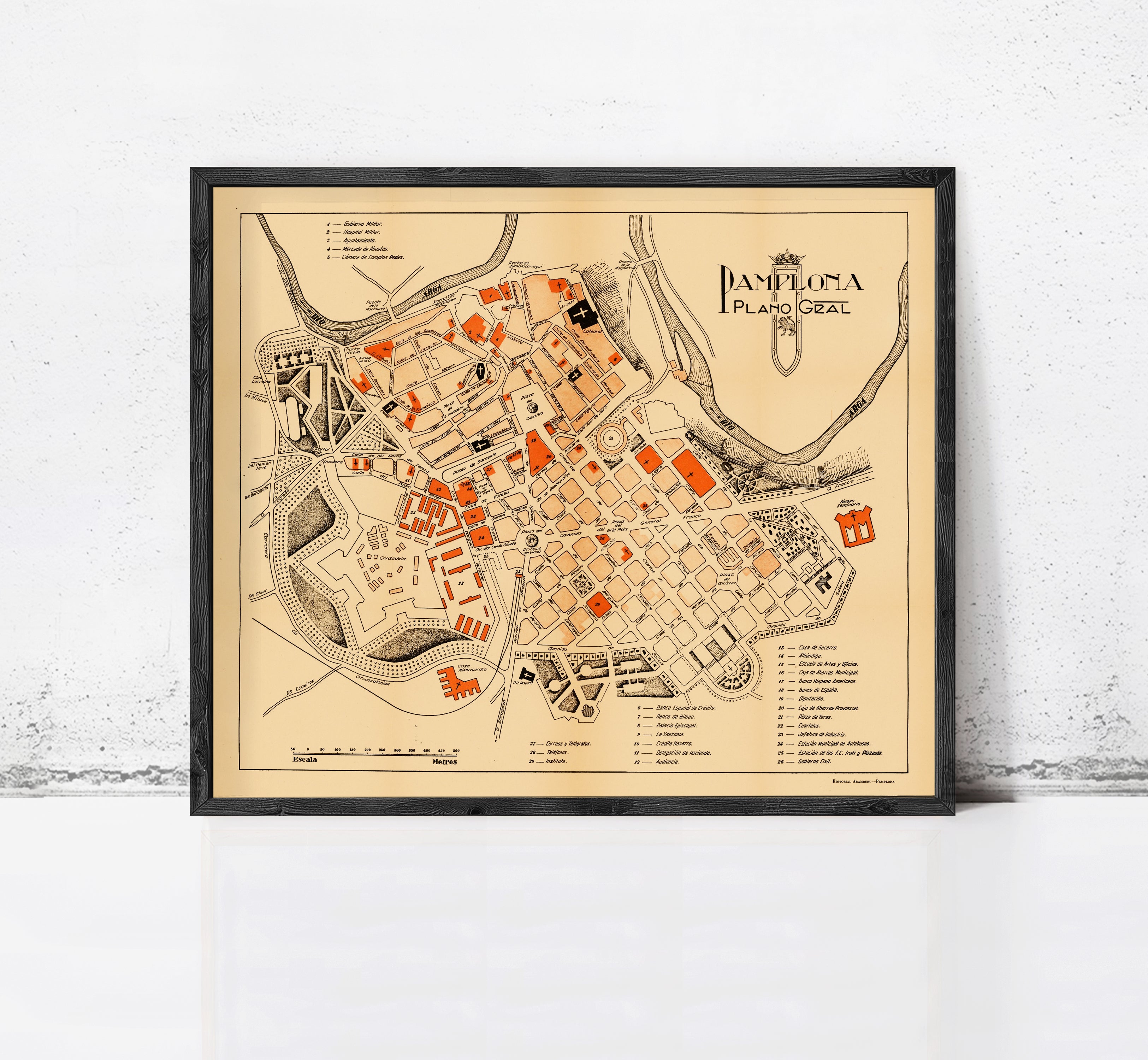 The image is a framed map of the city of Pamplona, Spain, depicting the layout and various landmarks within the city.