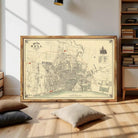 The image is a framed vintage map of a city, likely from the 19th century, depicting a detailed layout of streets, buildings, and other urban features.