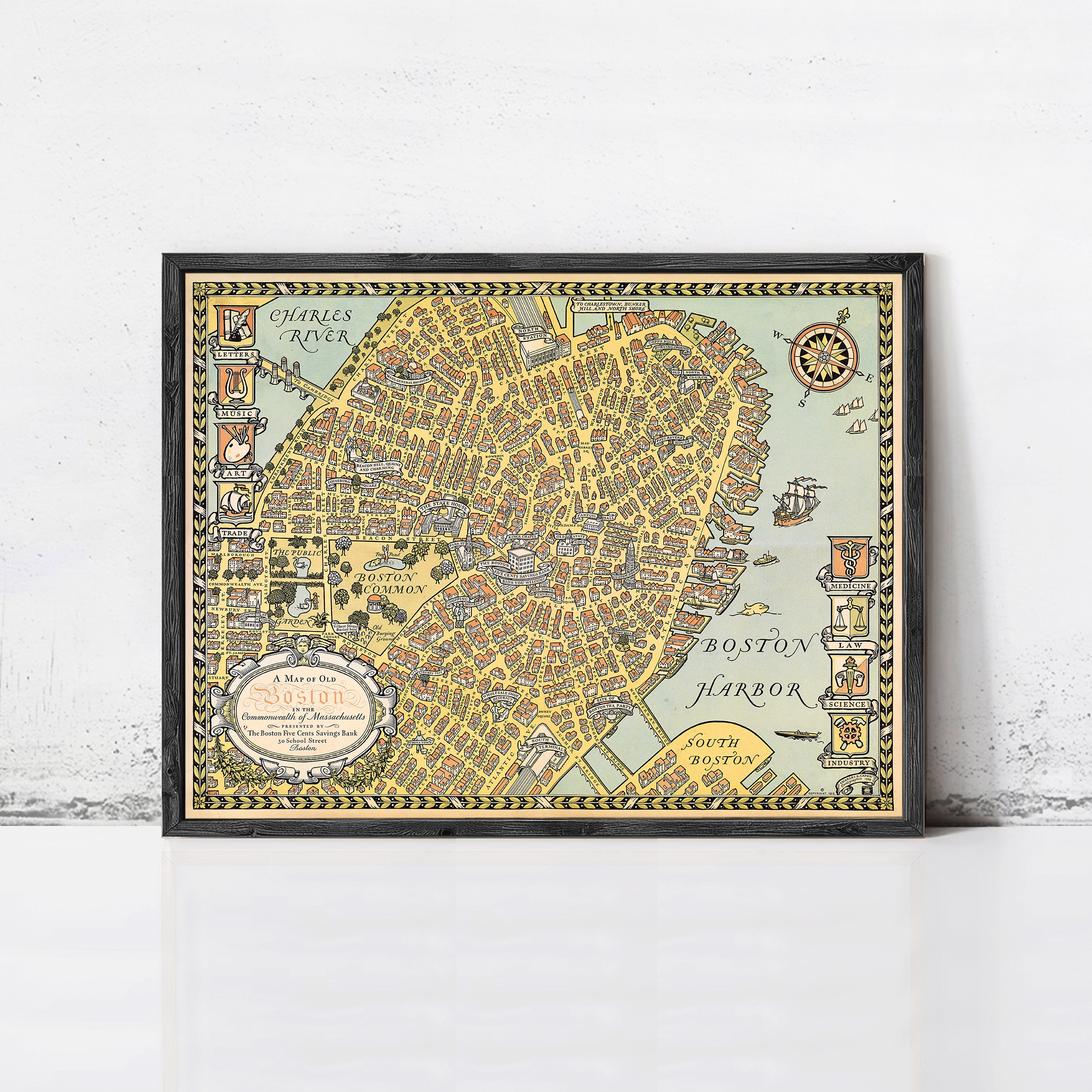 A framed vintage map of Boston, Massachusetts, depicting the city's streets and surrounding areas.