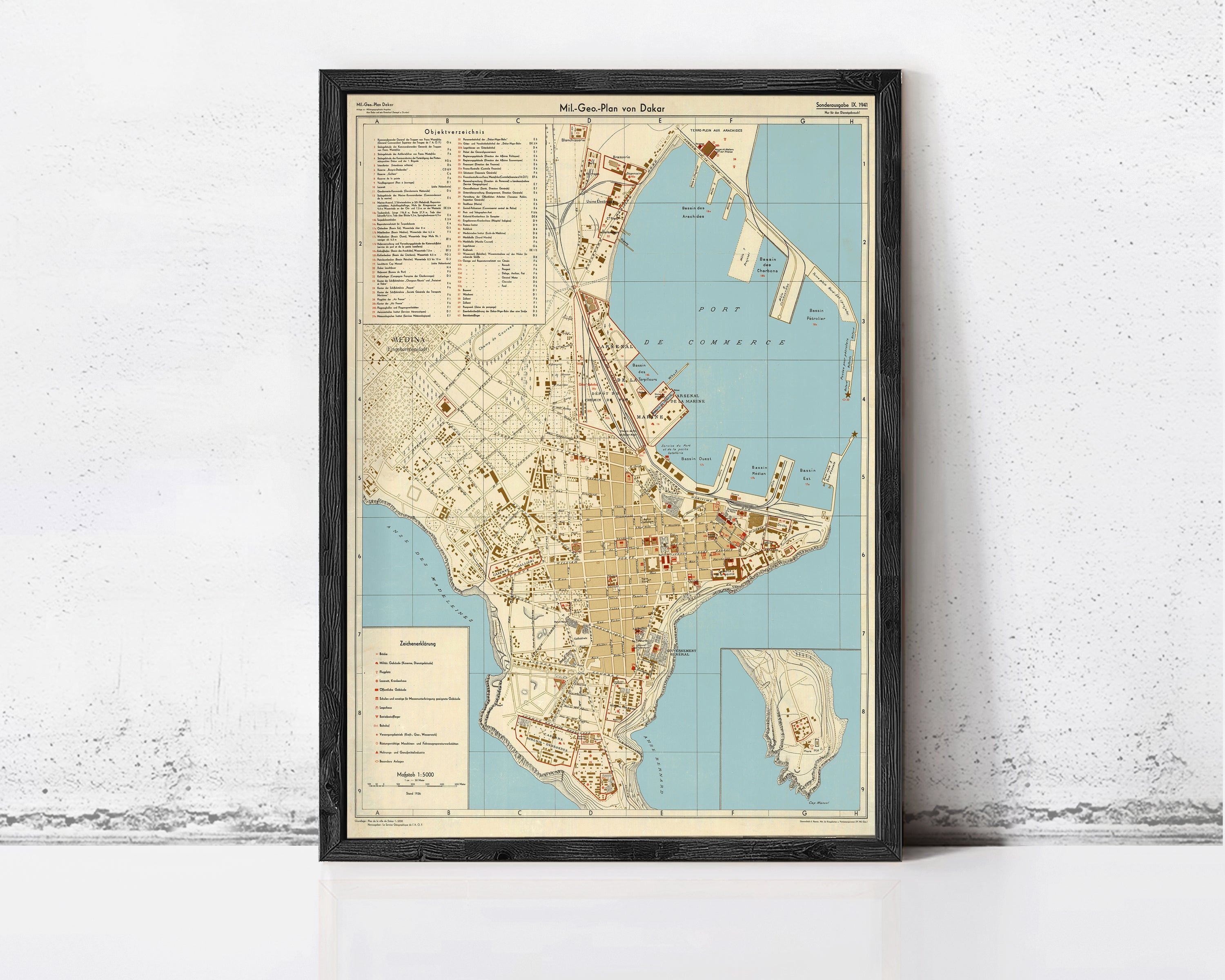 The image is a framed vintage map of a city, likely from the 19th century, displayed on a wall.
