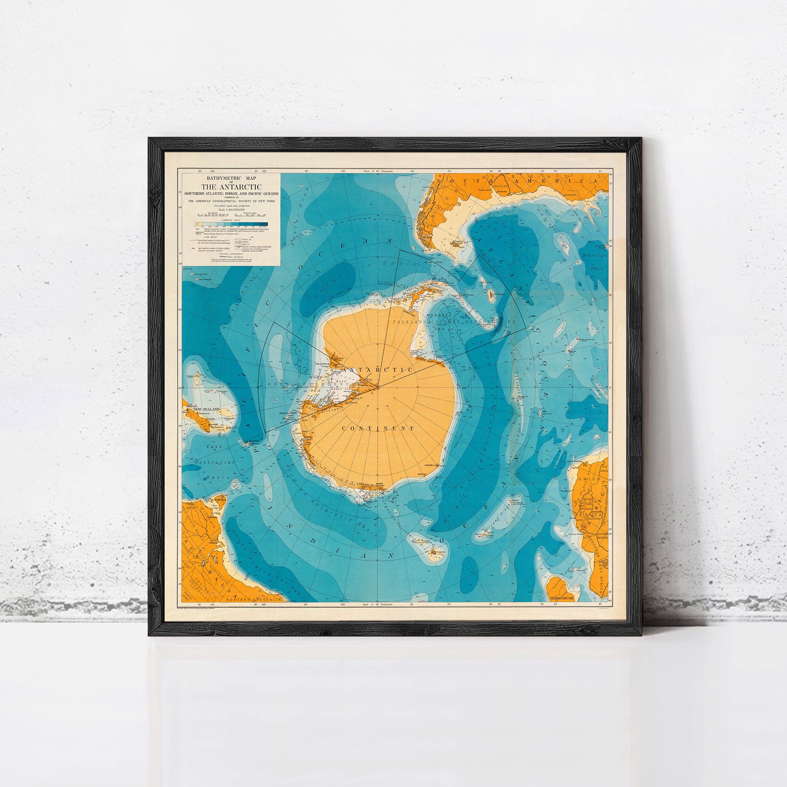 The image is a framed map of the Antarctic continent, showing the surrounding waters and landmasses in a stylized and colorful manner.